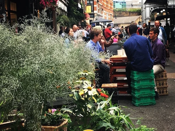 People sitting on plastic boxes in Borough market