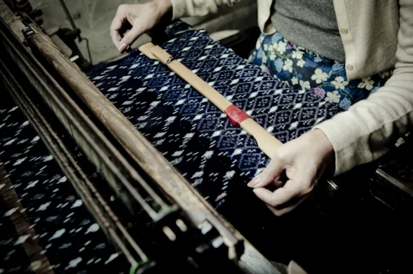 Kasuri is a Japanese word for fabric that has been woven with fibers dyed specifically to create patterns and images in the fabric. When woven together, the undyed areas interlace to form patterns. Image by Kurume Kasuri textile.