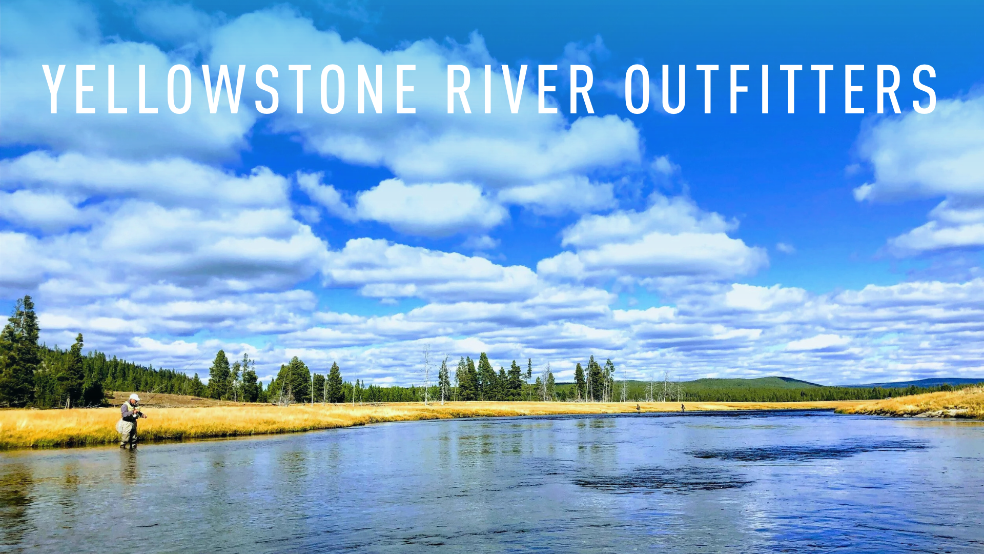 Yellowstone river and mountains with fly fishermen wading it it.