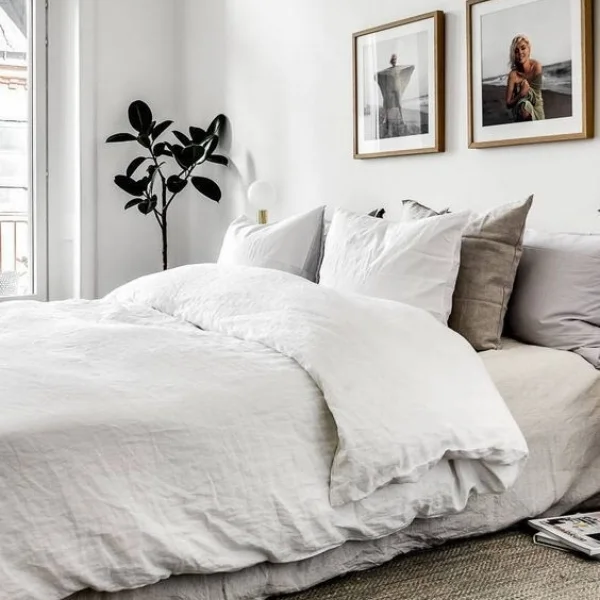 Bed with white duvet and multi-coloured pillows
