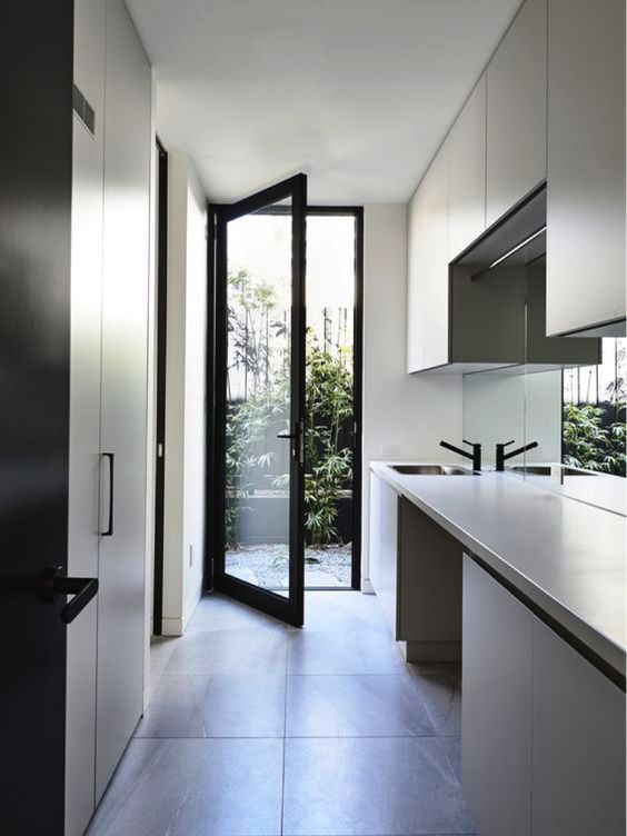 I love the use of black handles and tap ware in this laundry. They compliment the colour of the joinery, making everything look cohesive. The mirror splash back is such a smart choice in here! it reflects light really well and makes this narrow space feel a lot wider.