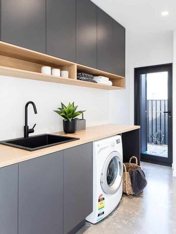 Don't be afraid to go for a laundry that isn't white! if you have the luxury of a larger laundry that has plenty of light, splash out and do something bold! I love this charcoal cabinetry, black basin and tap, they tie in with the black joinery and create a lovely flow to the outdoor area. Once again they are utilising the high ceiling for full height cabinets which is great!