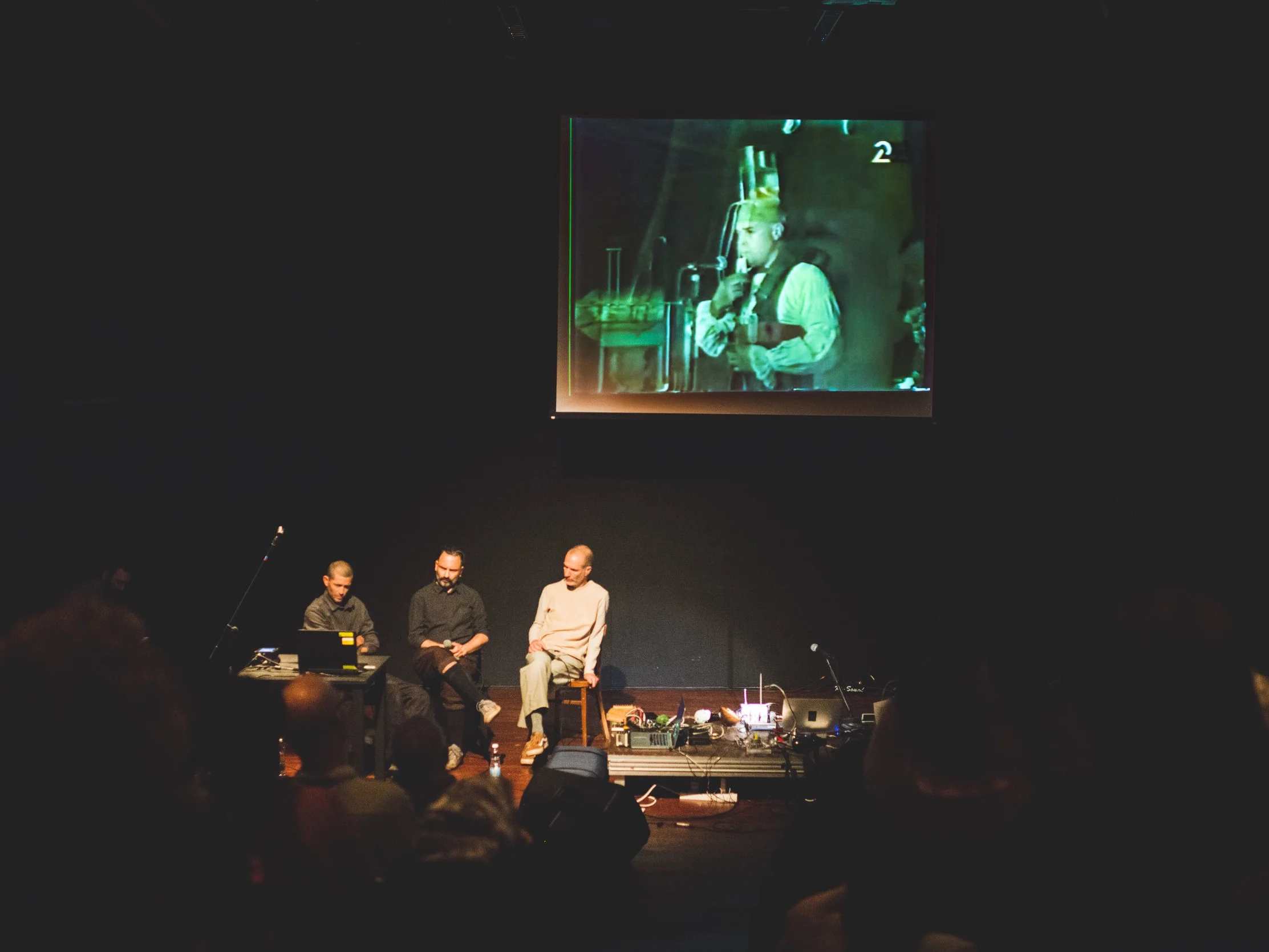 Ohad Fishof, Yishai Adar, and Benia Reches and on the screen the performance video of “Panta Rai” in the background. Uri Katzenstein performed in the ensemble "Panta Rai" with Yossi Lederman of blessed memory, at the Roxanne Club in Tel Aviv in 1991.