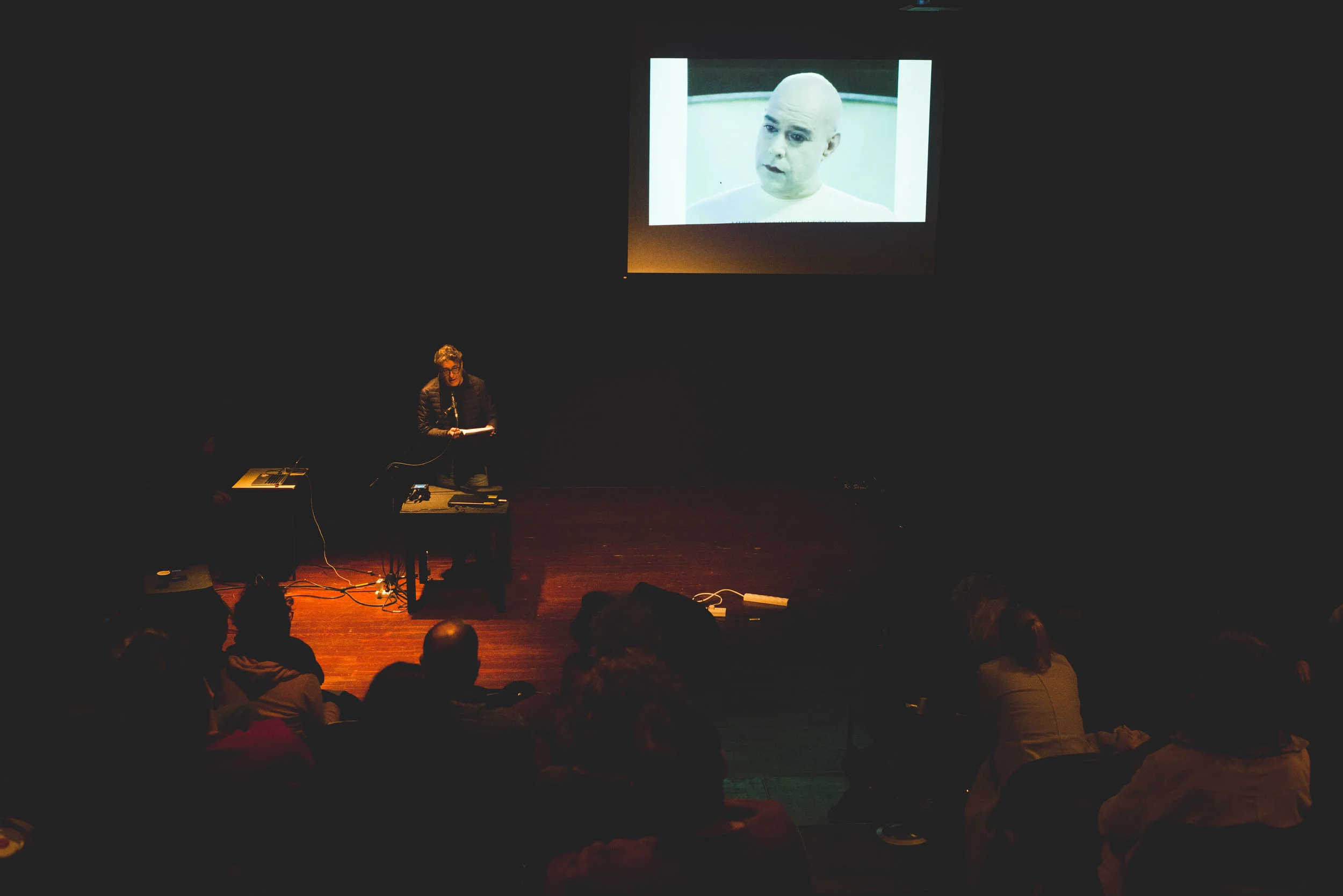 Sergio Edelstein In the background is a screening of Uri's video art, "Family of Brothers" from 1999.