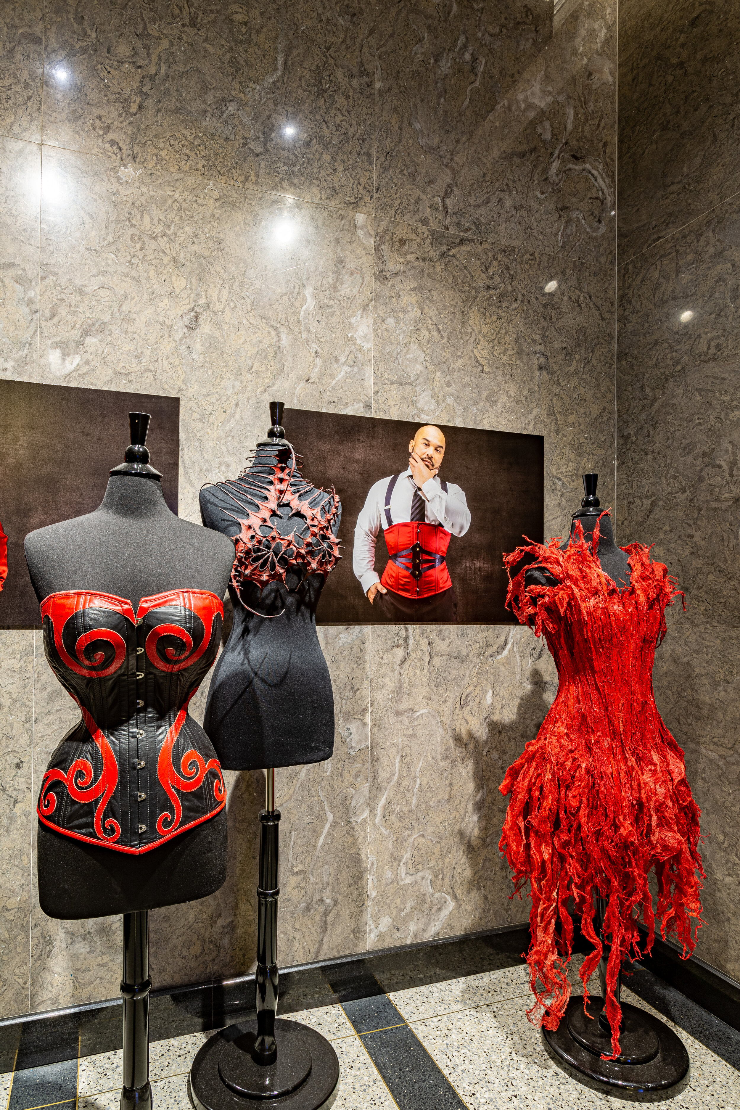  In the elevator alcove is a red and black leather corset made by   Dark Garden Corsetry   for Cathie Jung and  Nika Danielska ’s  Exoskeleton Bra.  These are displayed along with two male corsets and  Chie Ono ’s  Blood Red .   And    Portraits of R