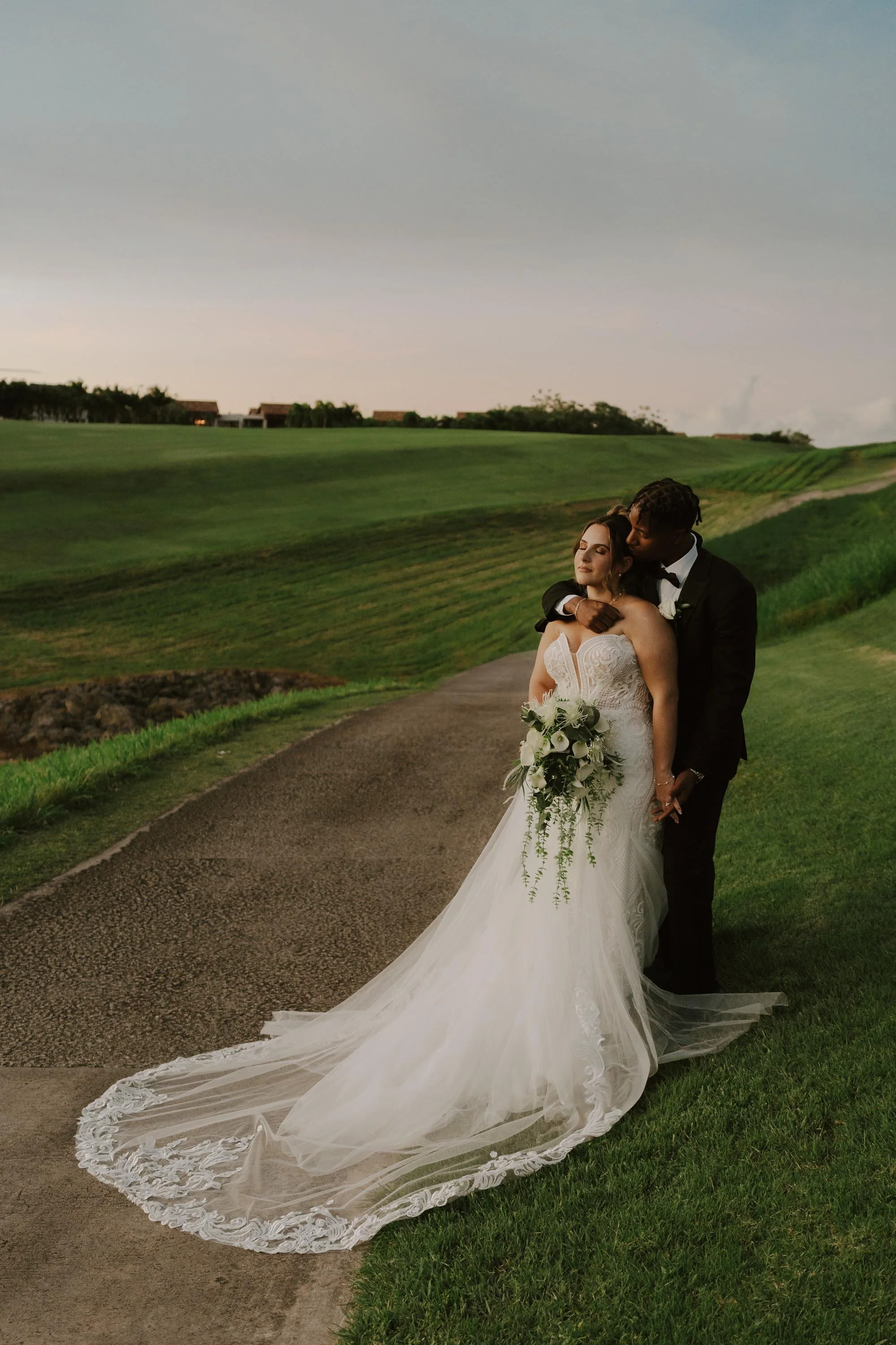 Bride and groom hugging on a golf course during sunset in Casa de Campo, Dominican Republic.