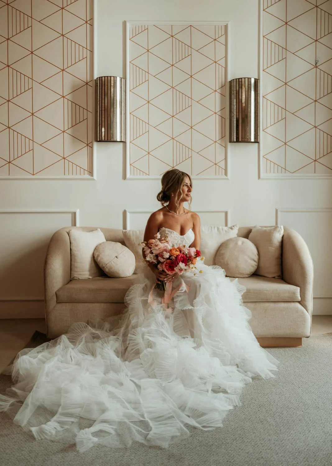 A bride sitting down in a couch with a beutiful bouquet in her getting ready in Dreams Macao