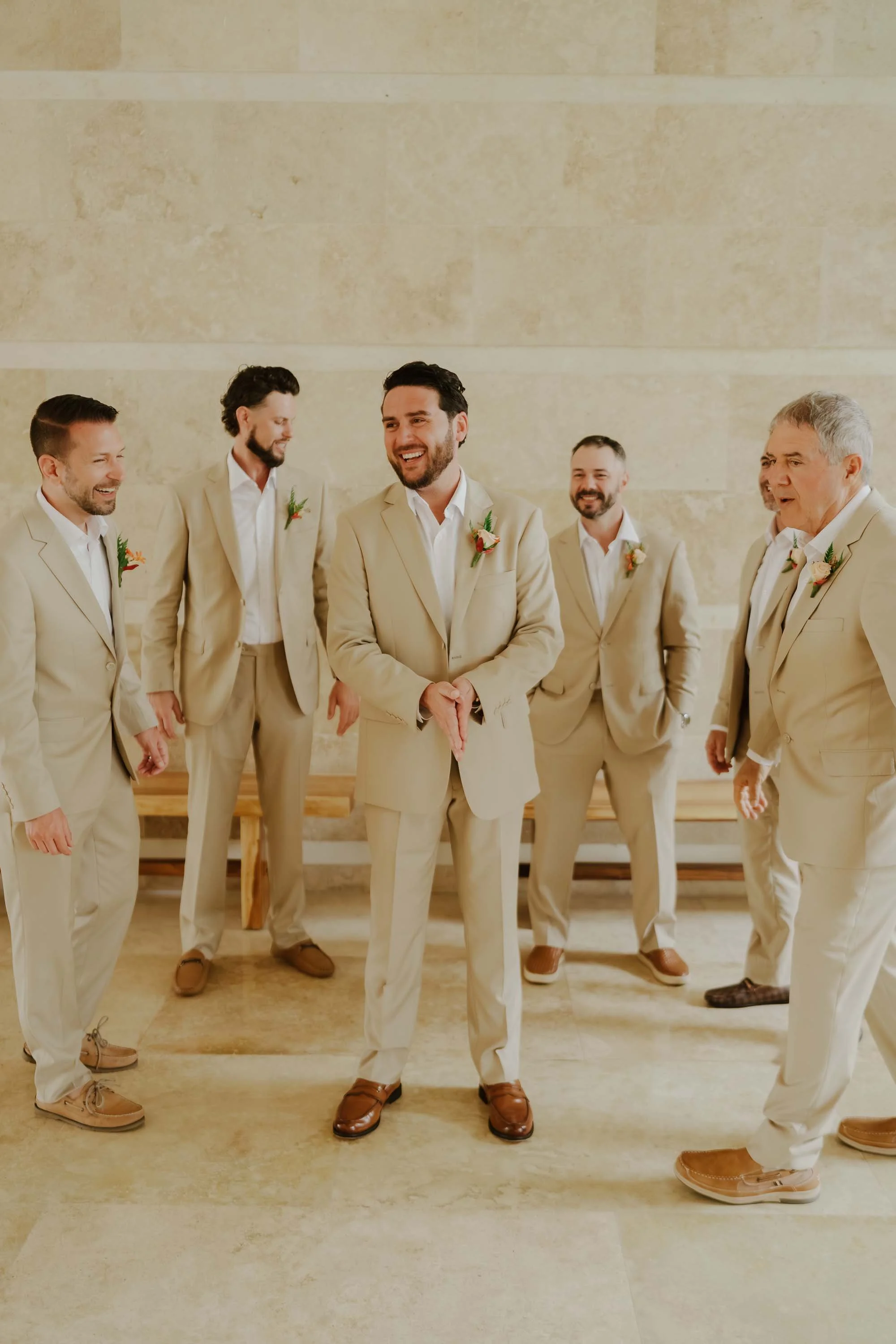Groom with the groomsmens standing and laughing for candid pose