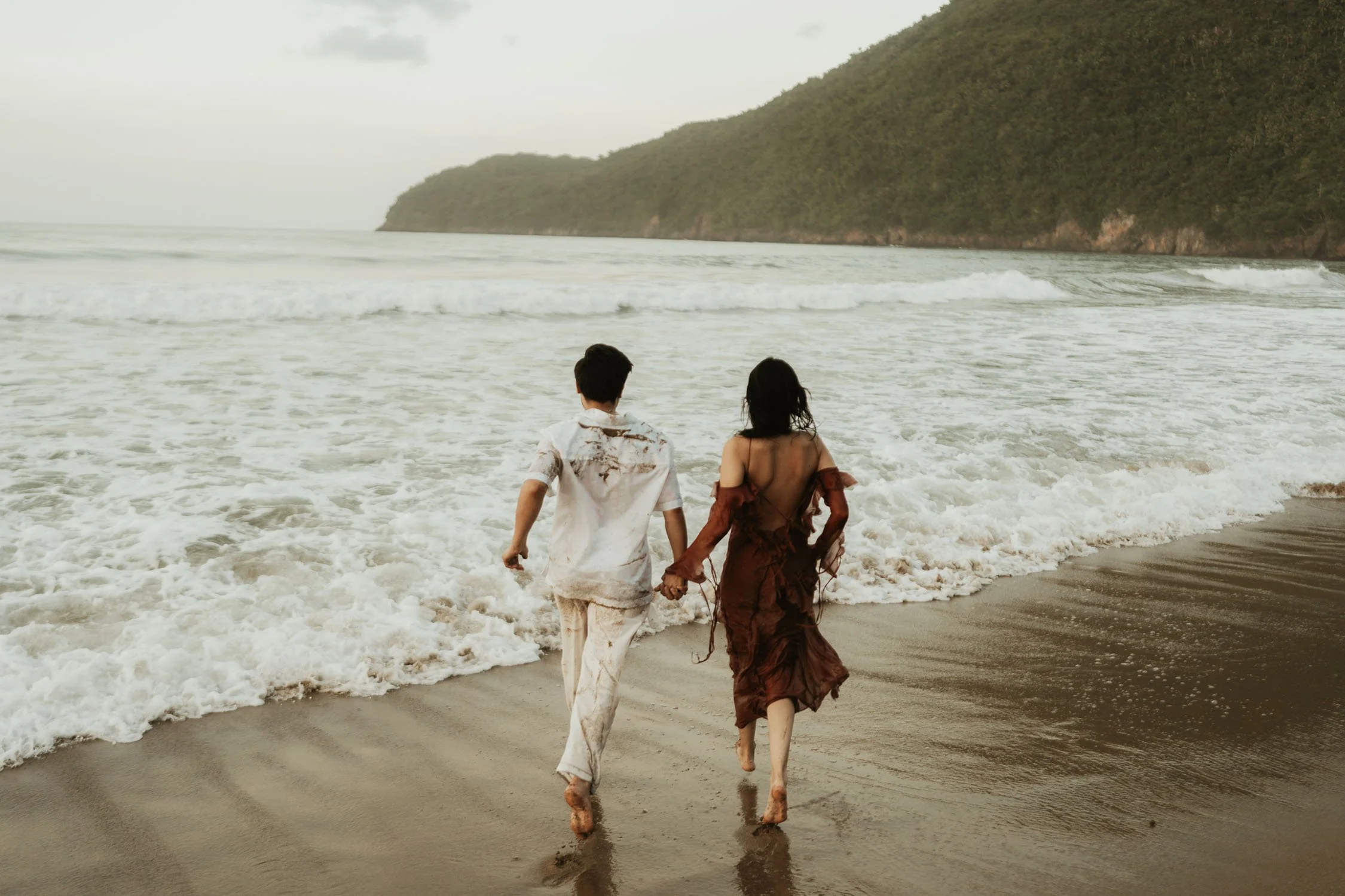 couple running towards the beach in an engagement photoshoot in samana dominican republic