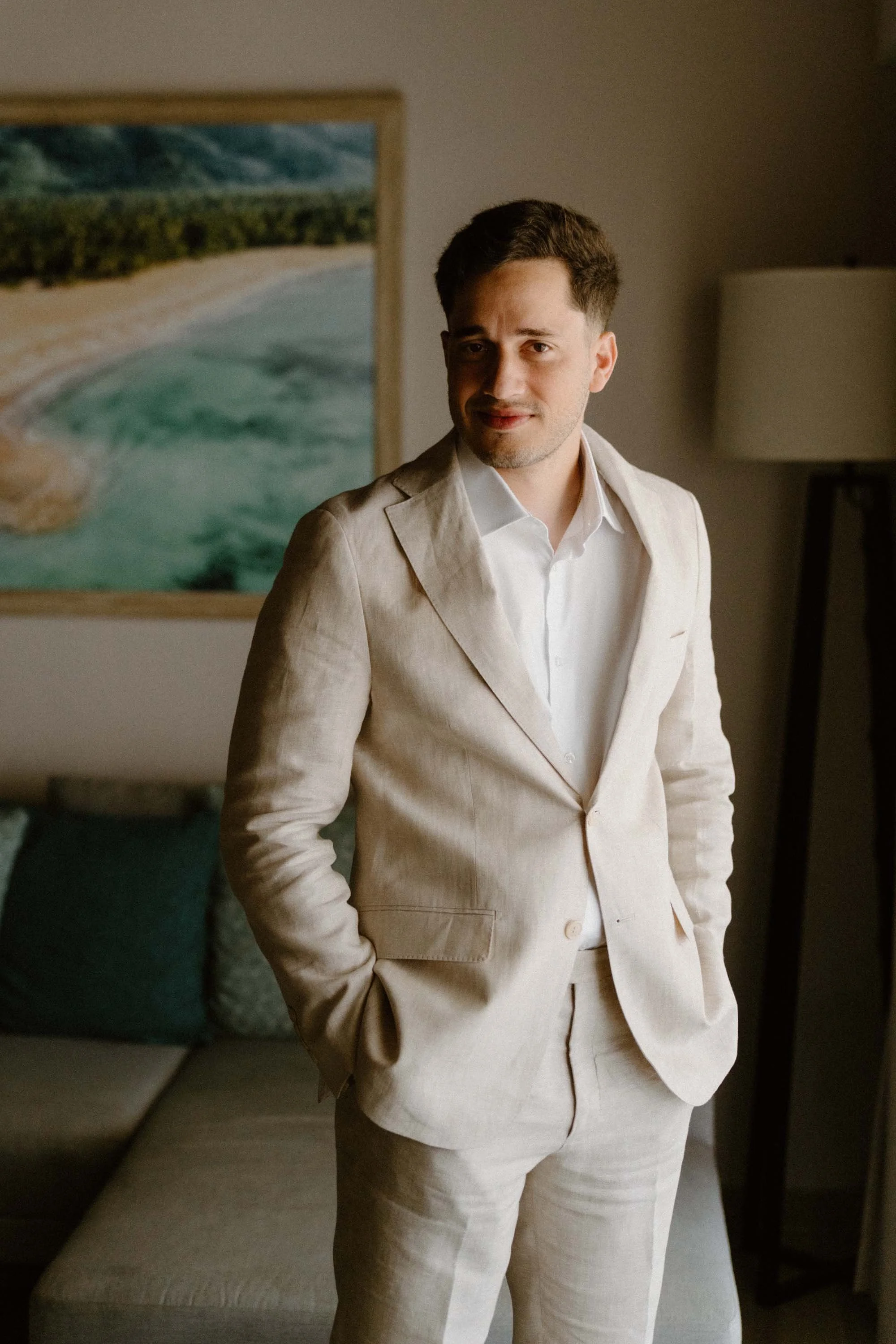 A warm, editorial portrait of a relaxed groom looking confident in a classic linen suit during his destination wedding morning in Cap Cana Punta Cana