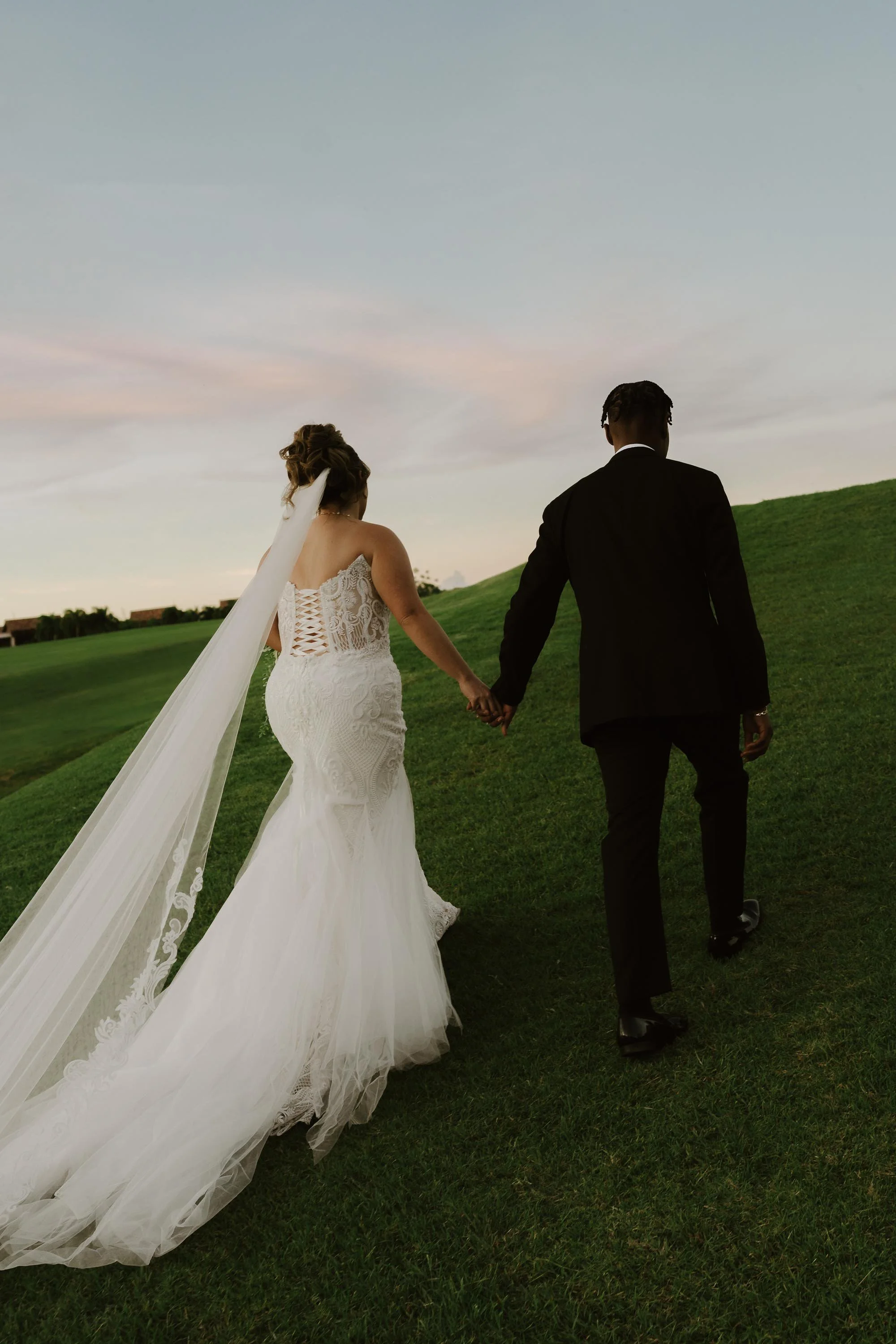 bride and groom holding hands and walking close to a golf camp close to Dye Fore in Casa de Campo