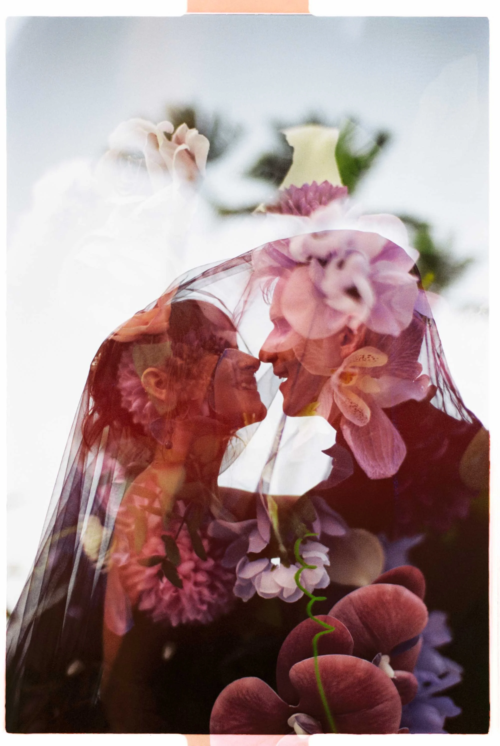 film double expousure photo of the couple lookign at each other. In the double expousure you can see the purple flowers and the bouquet of Tori