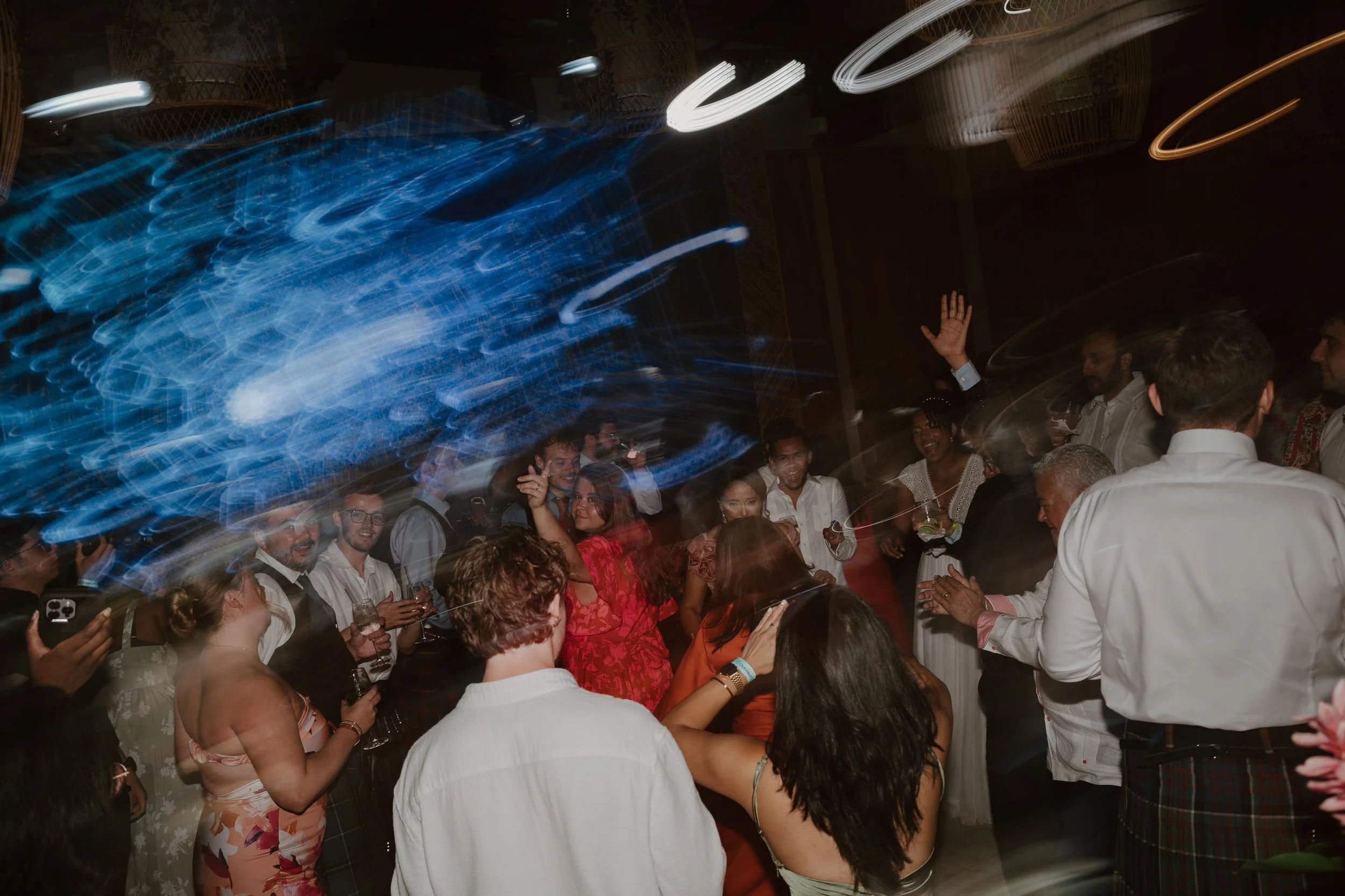 Candid and energetic wedding reception party in Punta Cana, with guests dancing and celebrating under warm lights
