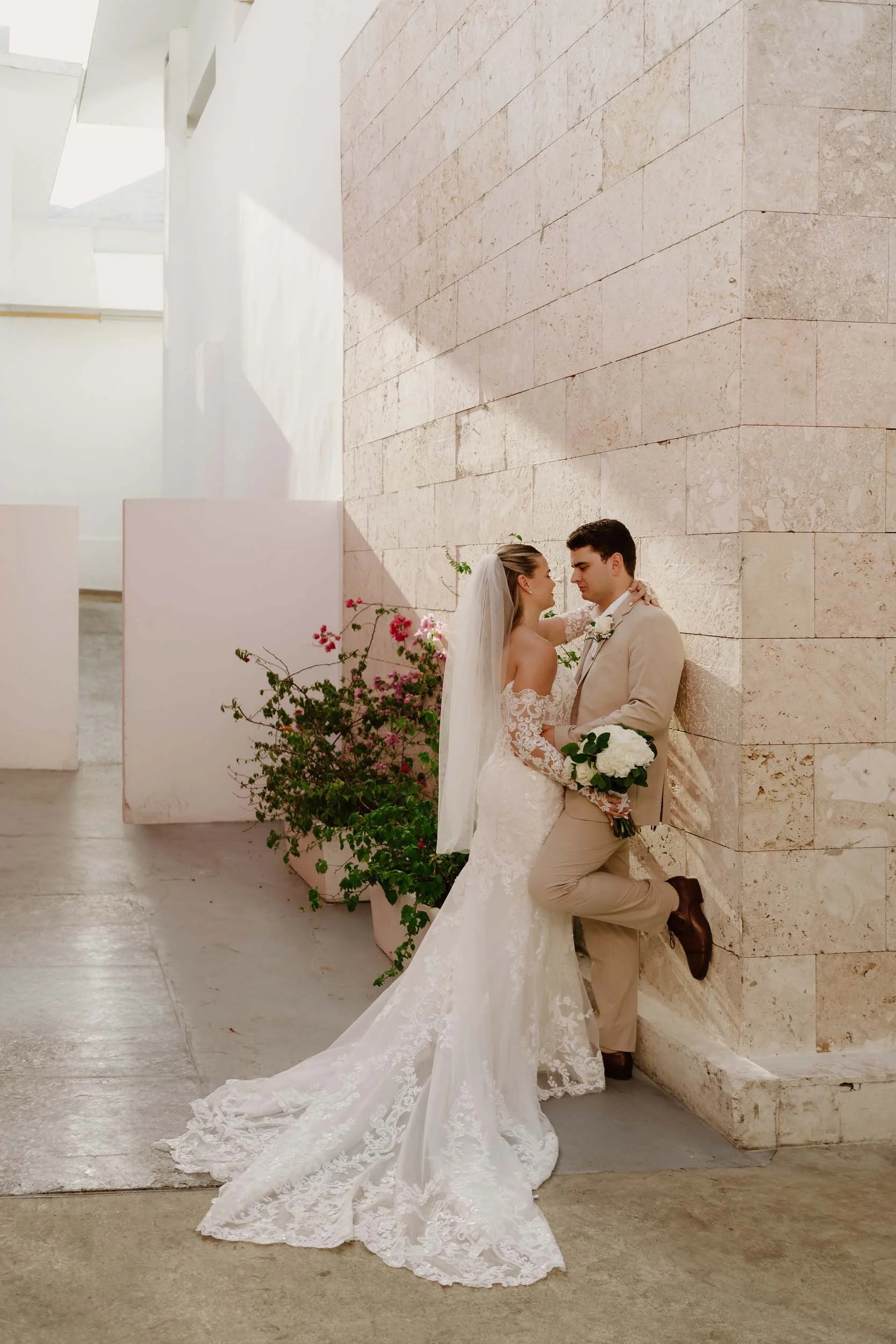 Couple posing against a wall for a photo