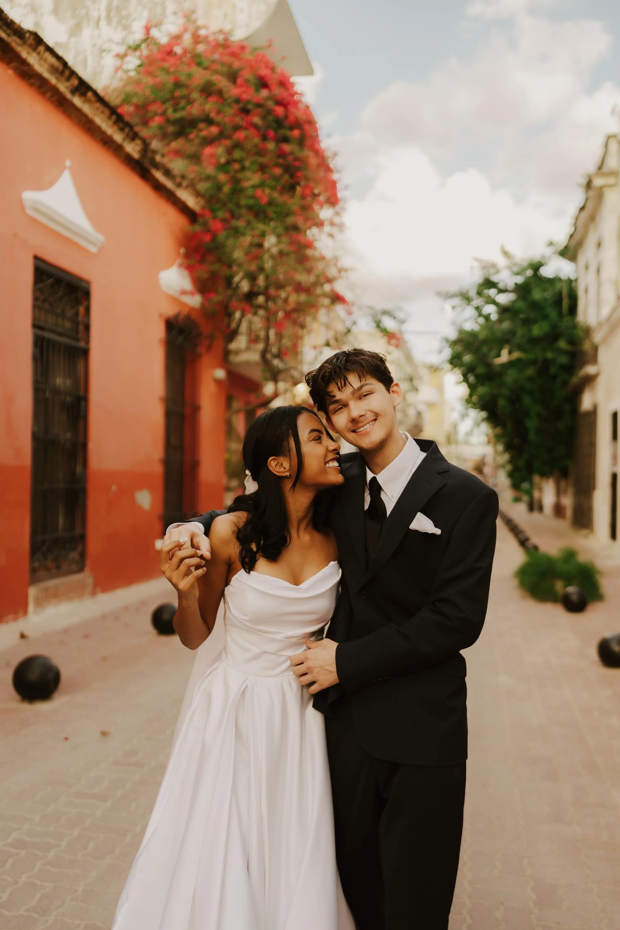 Newlywed couple walking and smiling along a cobblestone street in the Zona Colonial of Santo Domingo.