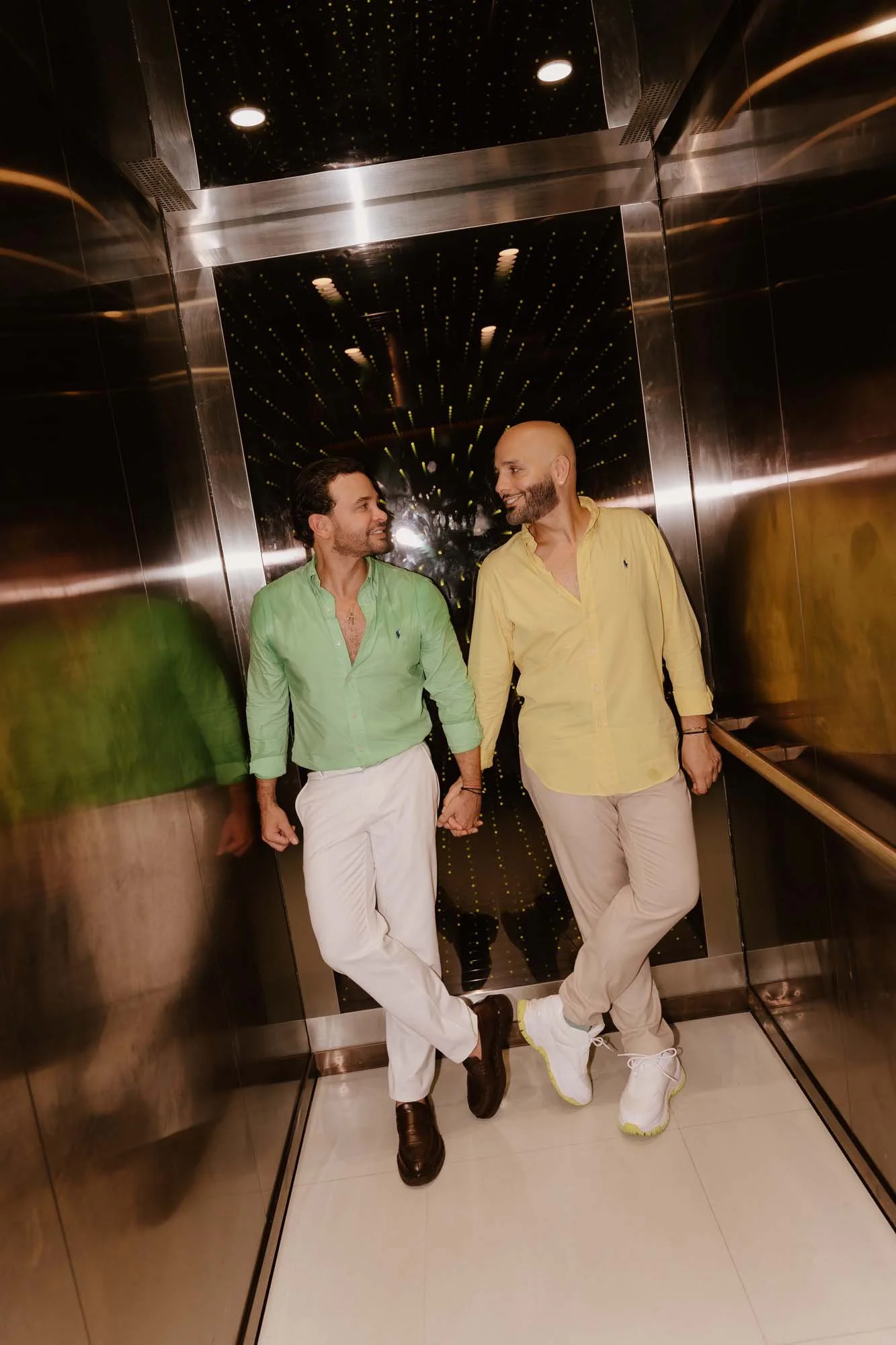Same sex couple holding hands in a elevator in Kimpton Las Mercesdes