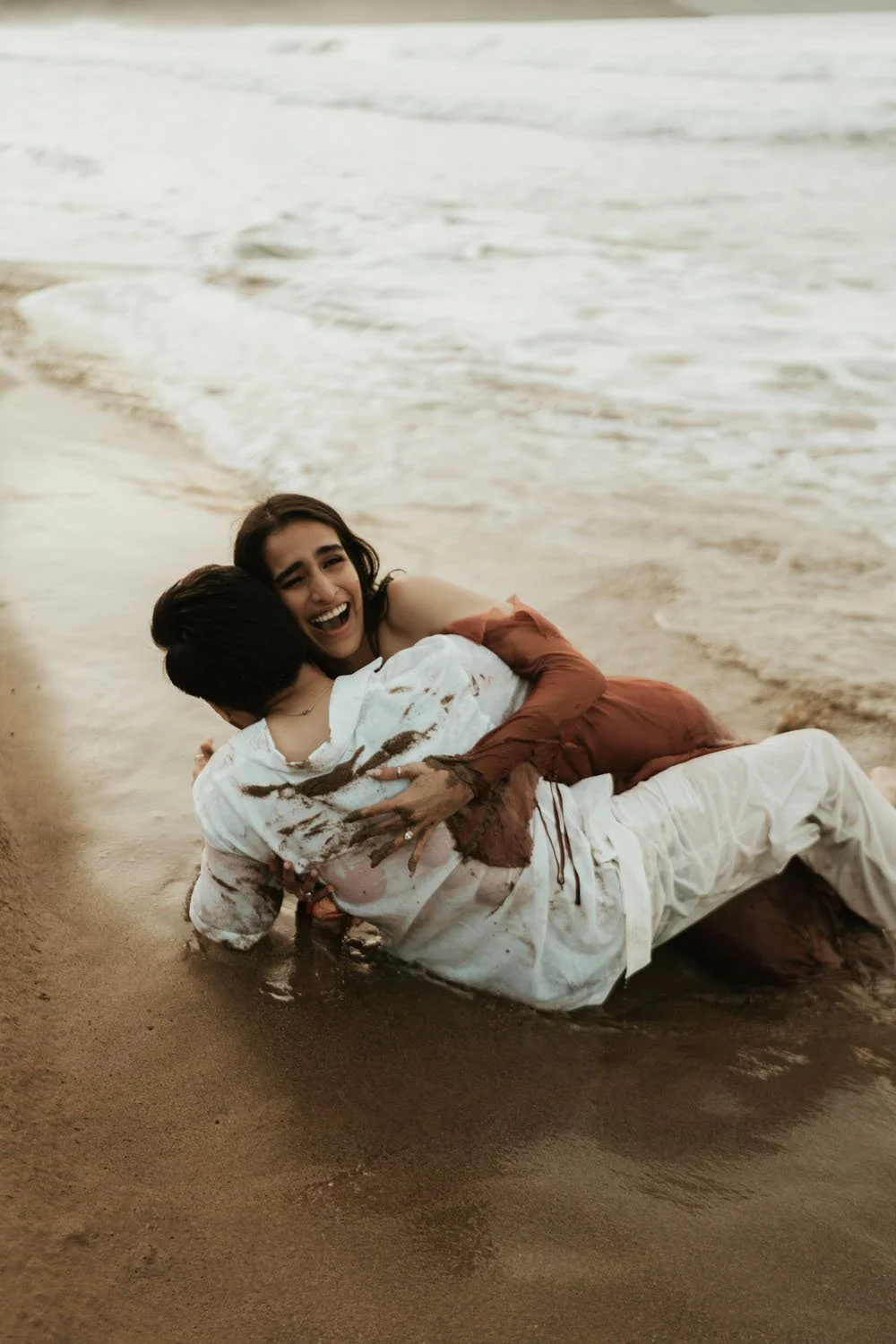 couple playing in the sand in engagement photoshoot in samana dominican republic