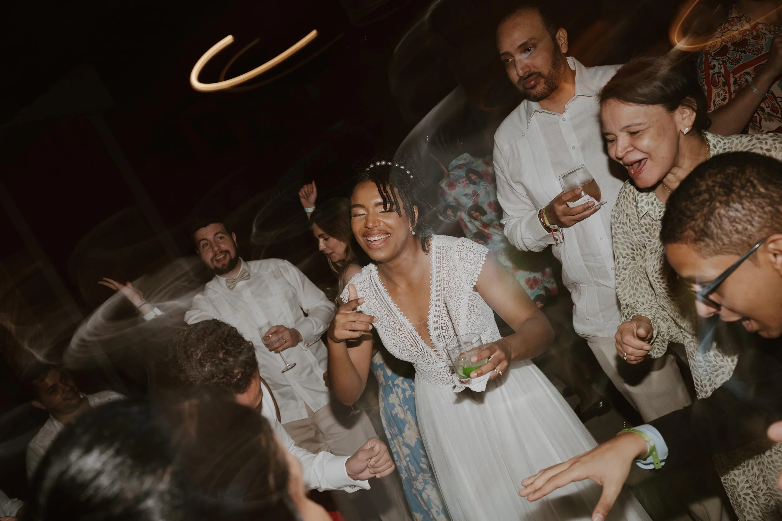 Candid and energetic wedding reception party in Punta Cana, with guests dancing and celebrating under warm lights