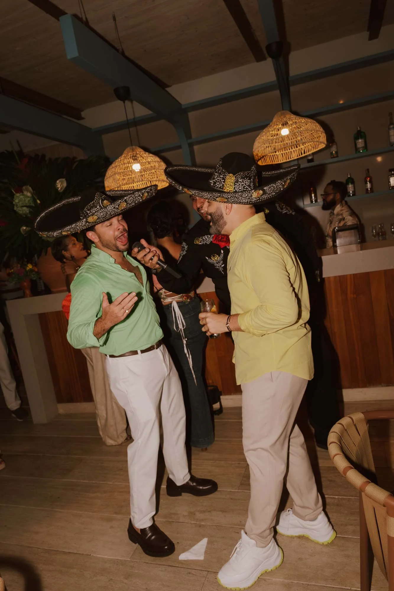 Same sex couple singing mariachi in the bar