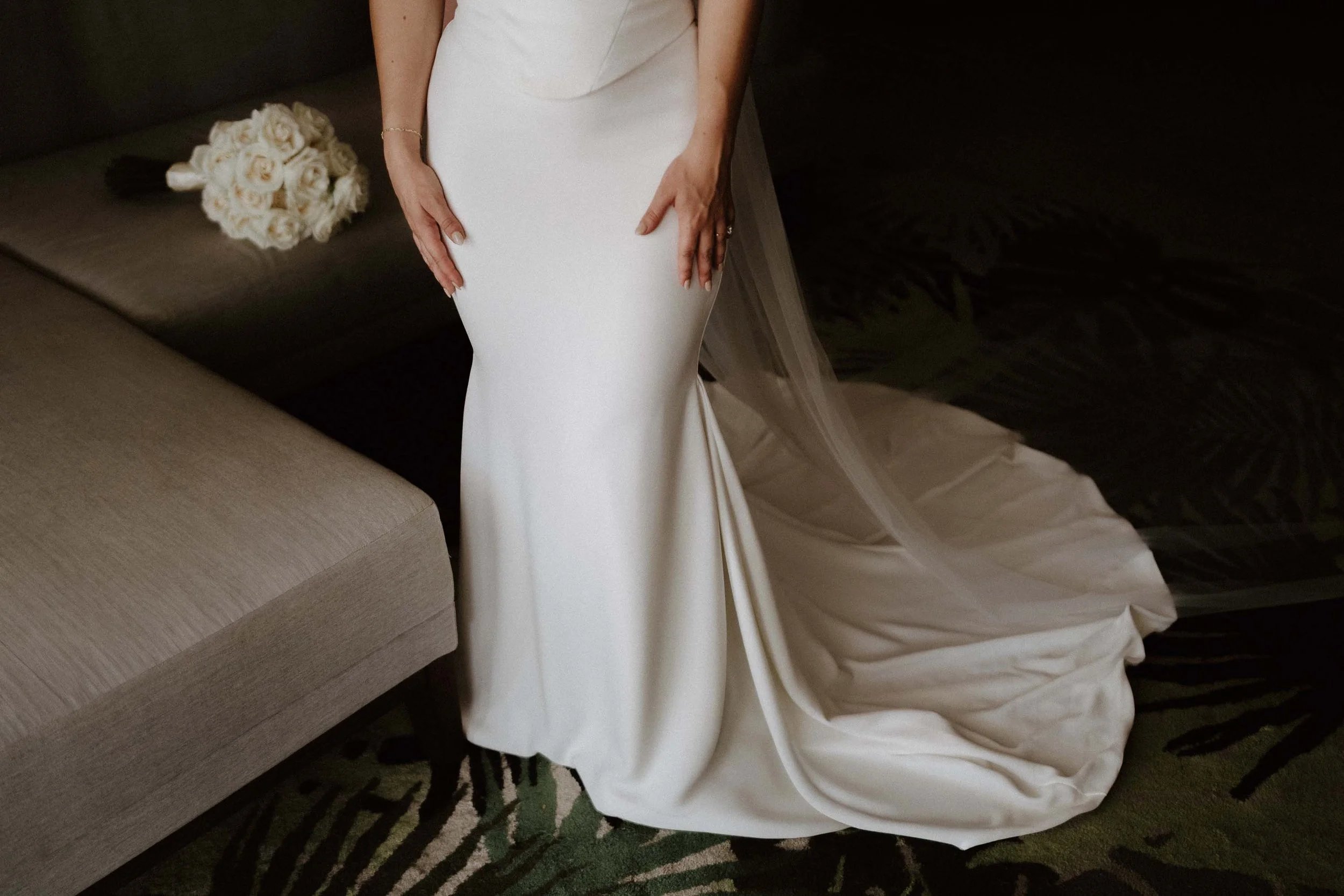 Bride getting ready while the white flowers bouquet are in the background