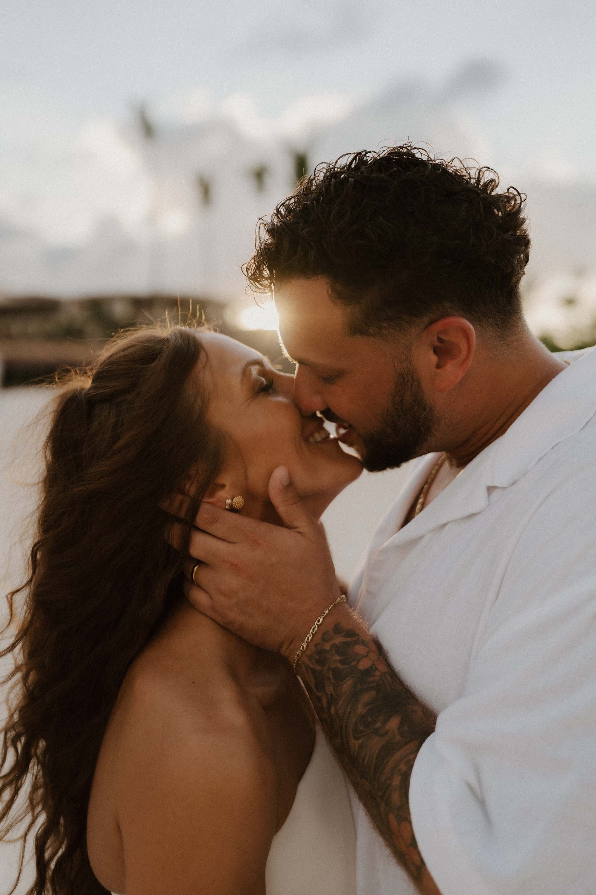 Sunset kissing photo of the bride and groom while almost kissing
