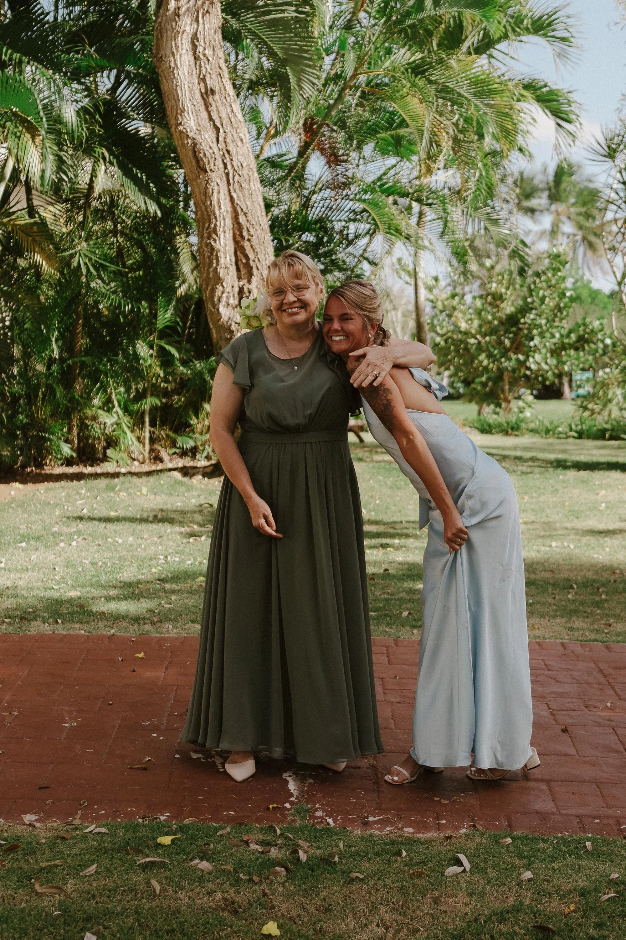 mom of the bride hugging one of the bridemaids, emotional, while watching the first look