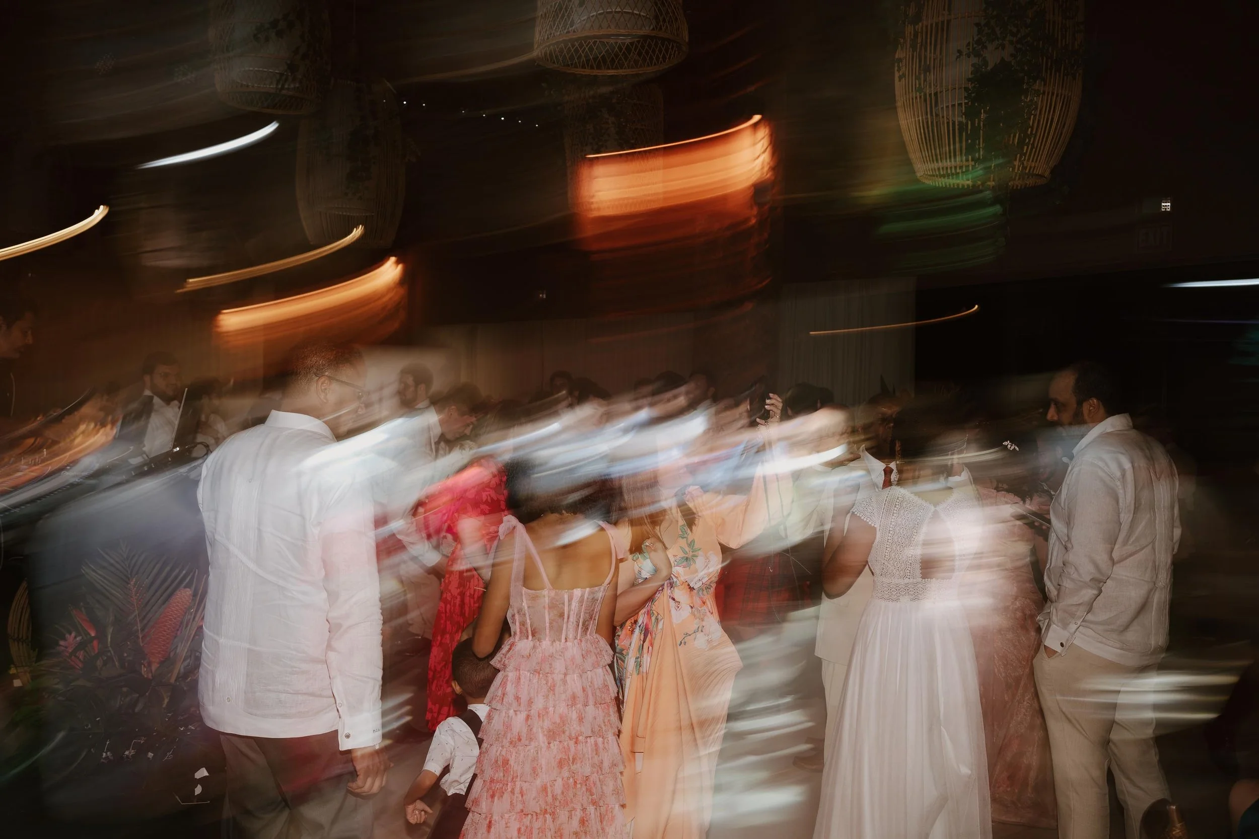 Candid and energetic wedding reception party in Punta Cana, with guests dancing and celebrating under warm lights