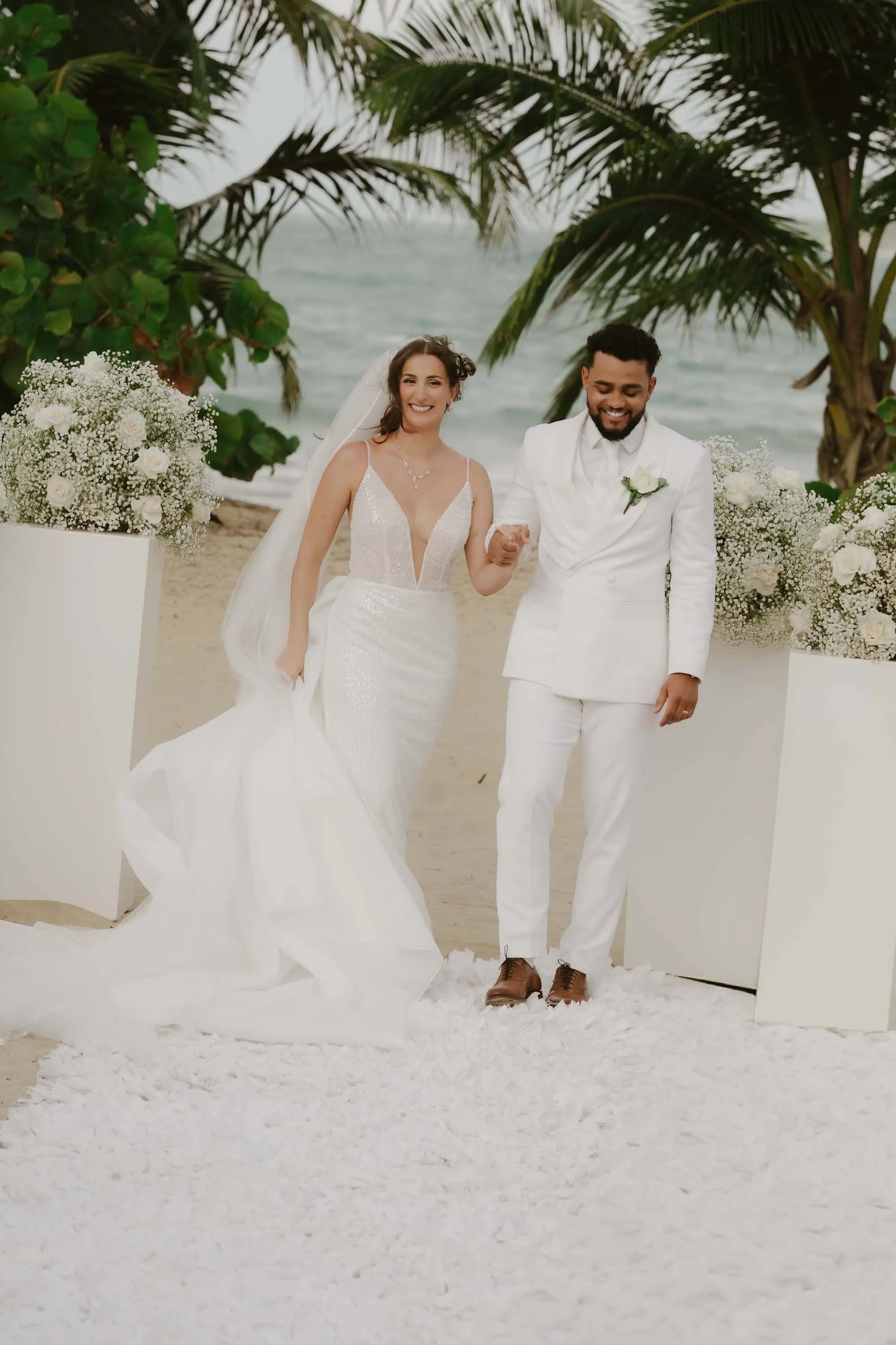 Bride and groom holding hands in the ceremony after the first kiss ready to walk down the aisle
