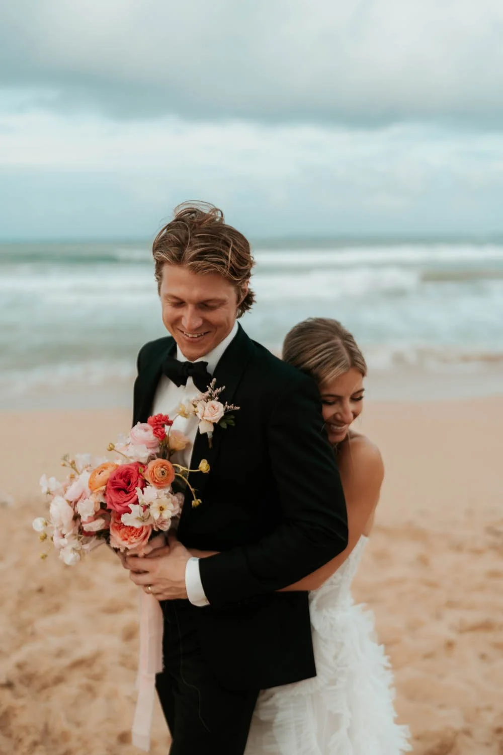 candid moment between bride and groom at the beach