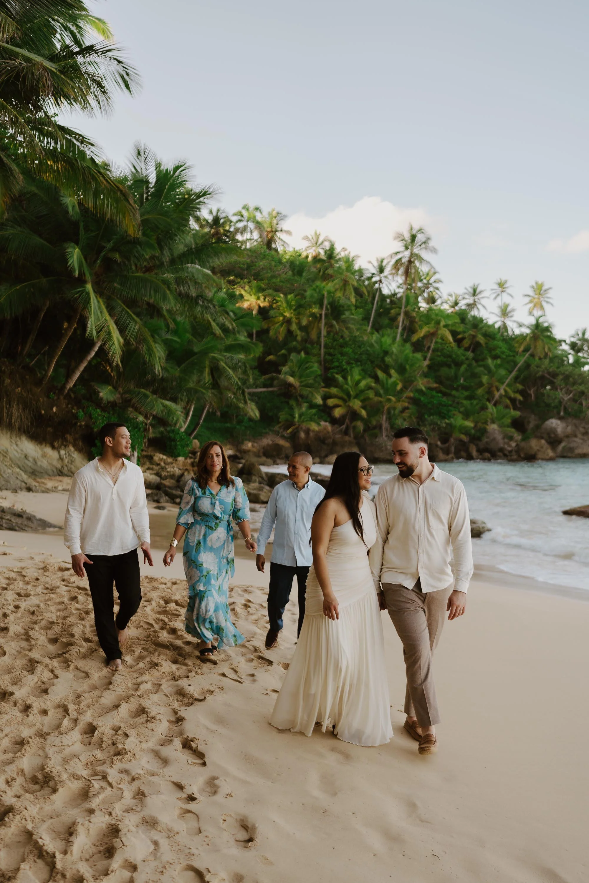 Family holding hands and walking in the beach in Cabrera