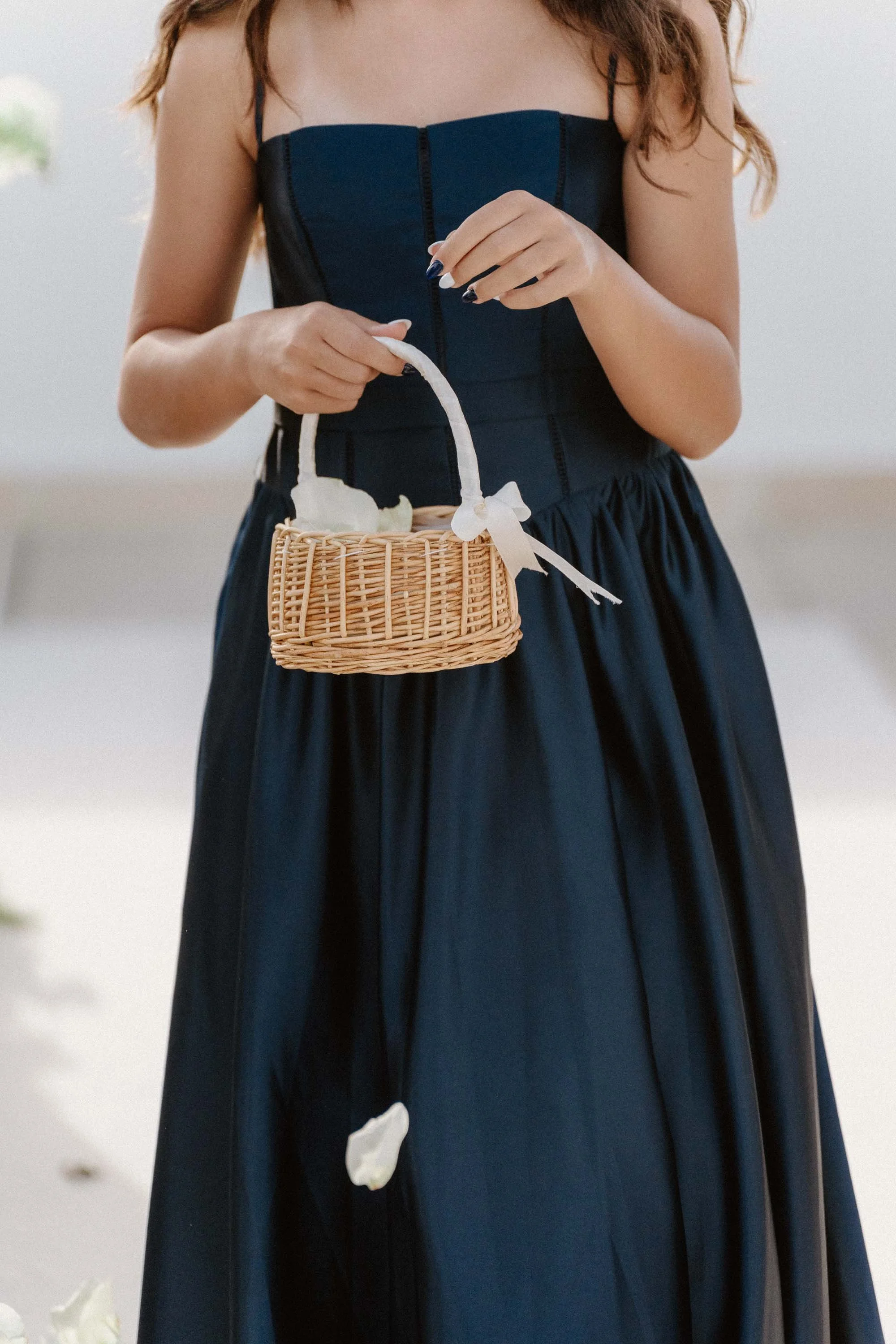 "An editorial, sweet photograph of the couple's daughter acting as the flower girl, holding a small woven basket as she walks down the aisle during an intimate destination wedding in Cap Cana Punta Cana."