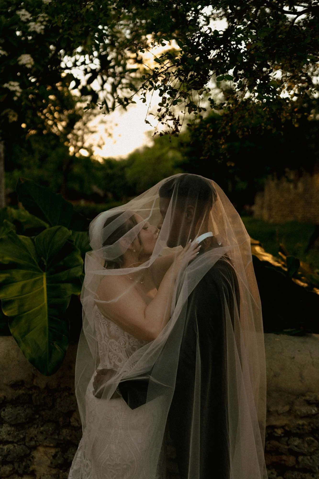 Couple kissing under the veil in the sunset in Altos de Chavon in Casa de Campo
