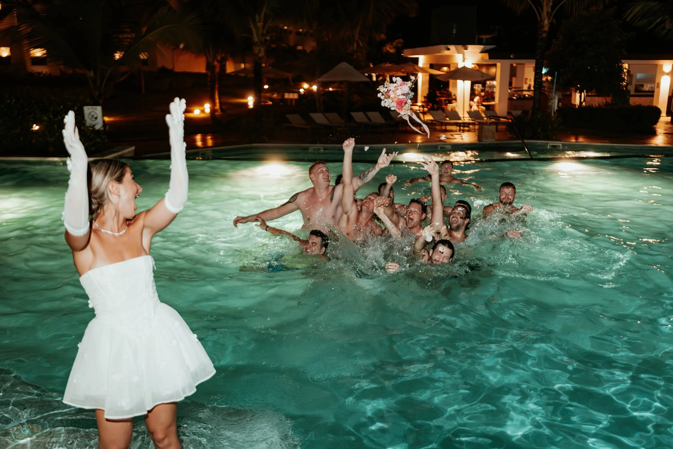 bride bouquet toss up in the pool