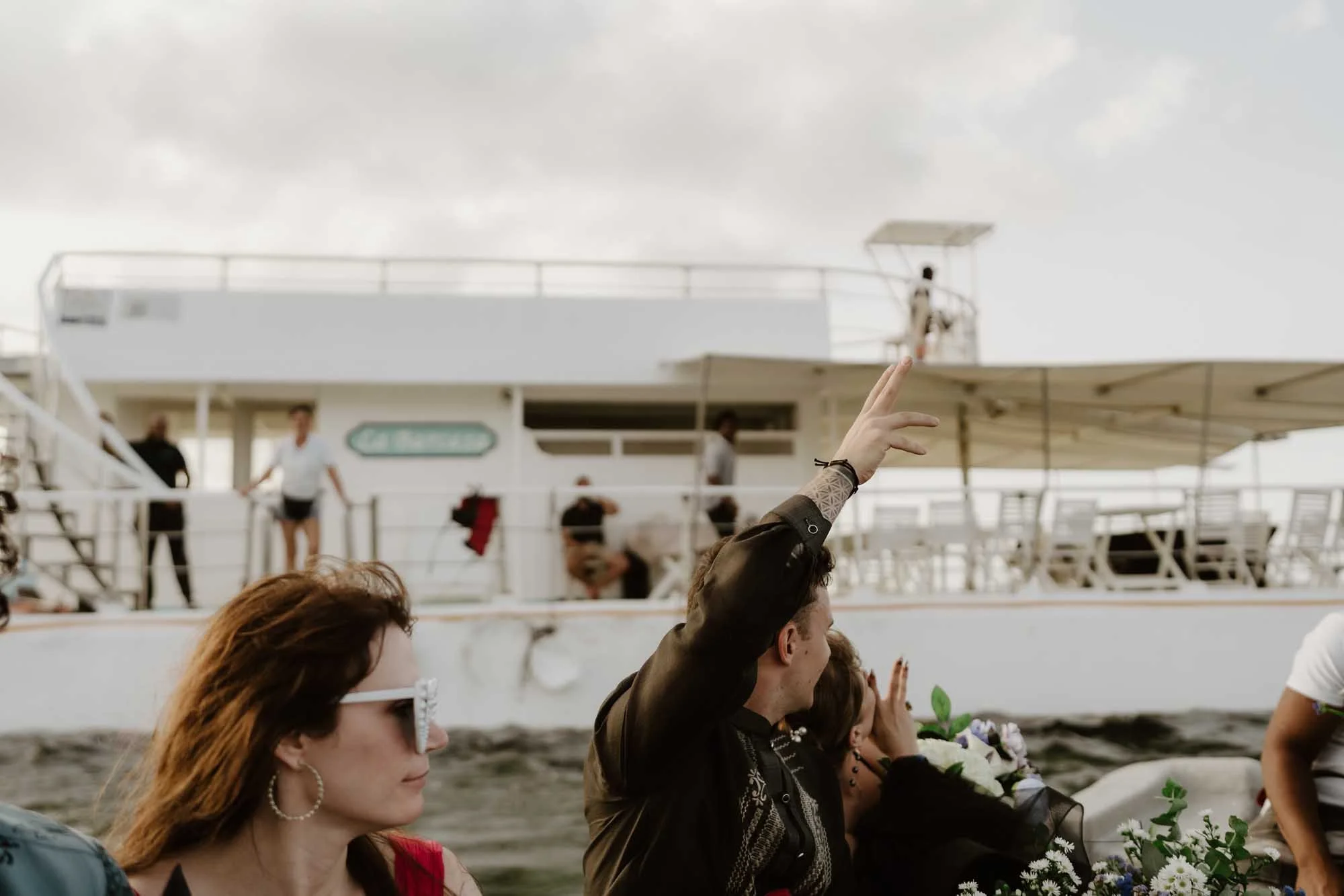 Photo of the groom in a small boat saying goodbye to La Barcaza while the reception finished