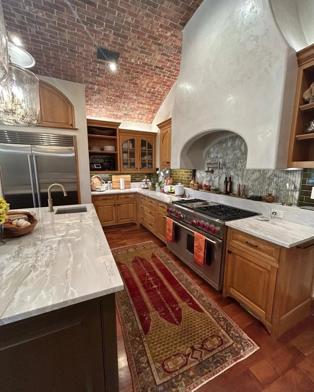 This one of a kind vent hood and backsplash installation features hand-selected stone and precision fabrication. Each fluted panel was cut and installed to maintain continuous veining, allowing the backsplash to integrate seamlessly with the vent hoo