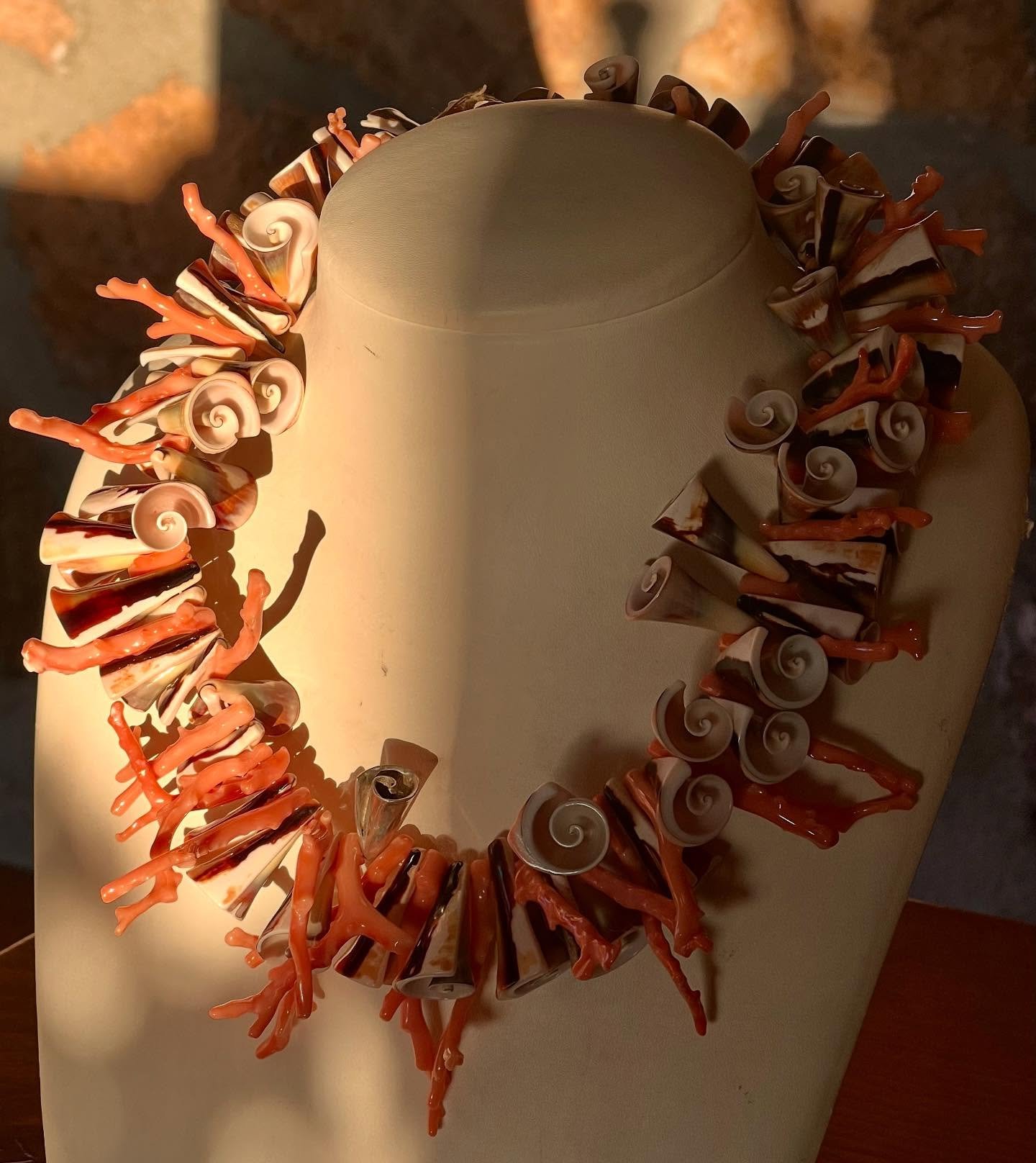 An Elisabethen collar of coral and shells for your décolleté!
This pink coral branches and polished cone shells collier is finished with sterling silver cone pieces and ofcourse Suzette’s signature 18k gold logo beetle is now av