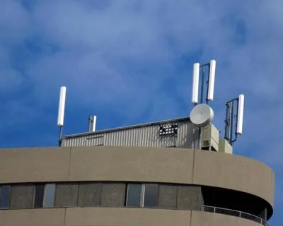 Typical cell phone towers look like tall skinny rectangles often mounted on the roof or sides of taller buildings and the round shaped tower is a radio or microwave tower.