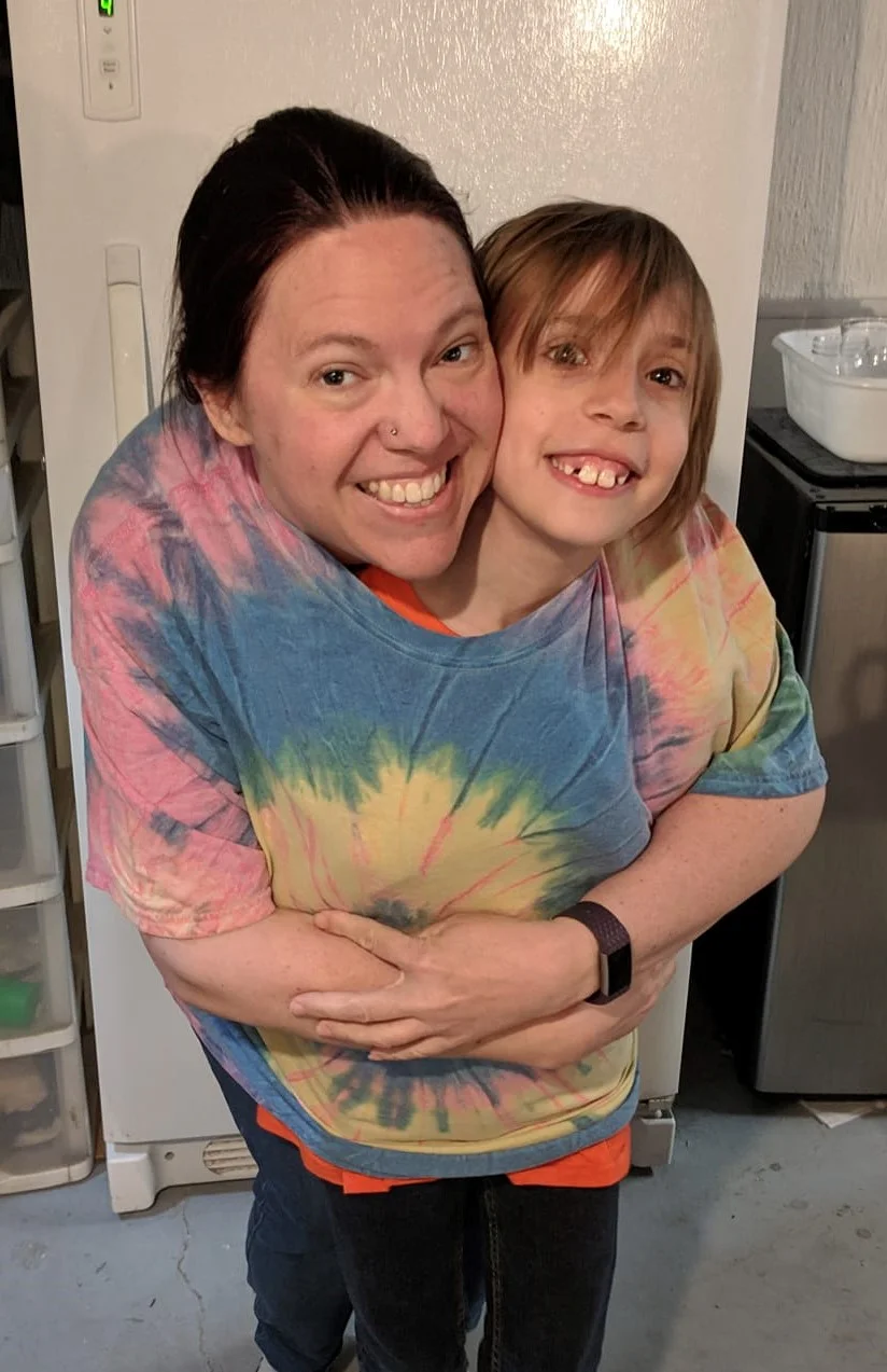 Amber & her son happily show off her now oversized clothing
