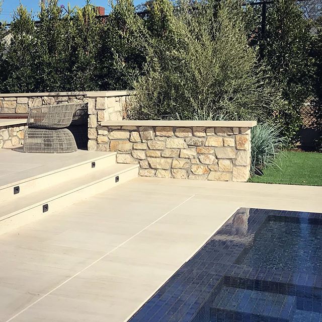Navy blue pool tile and warm limestone in Mar Vista