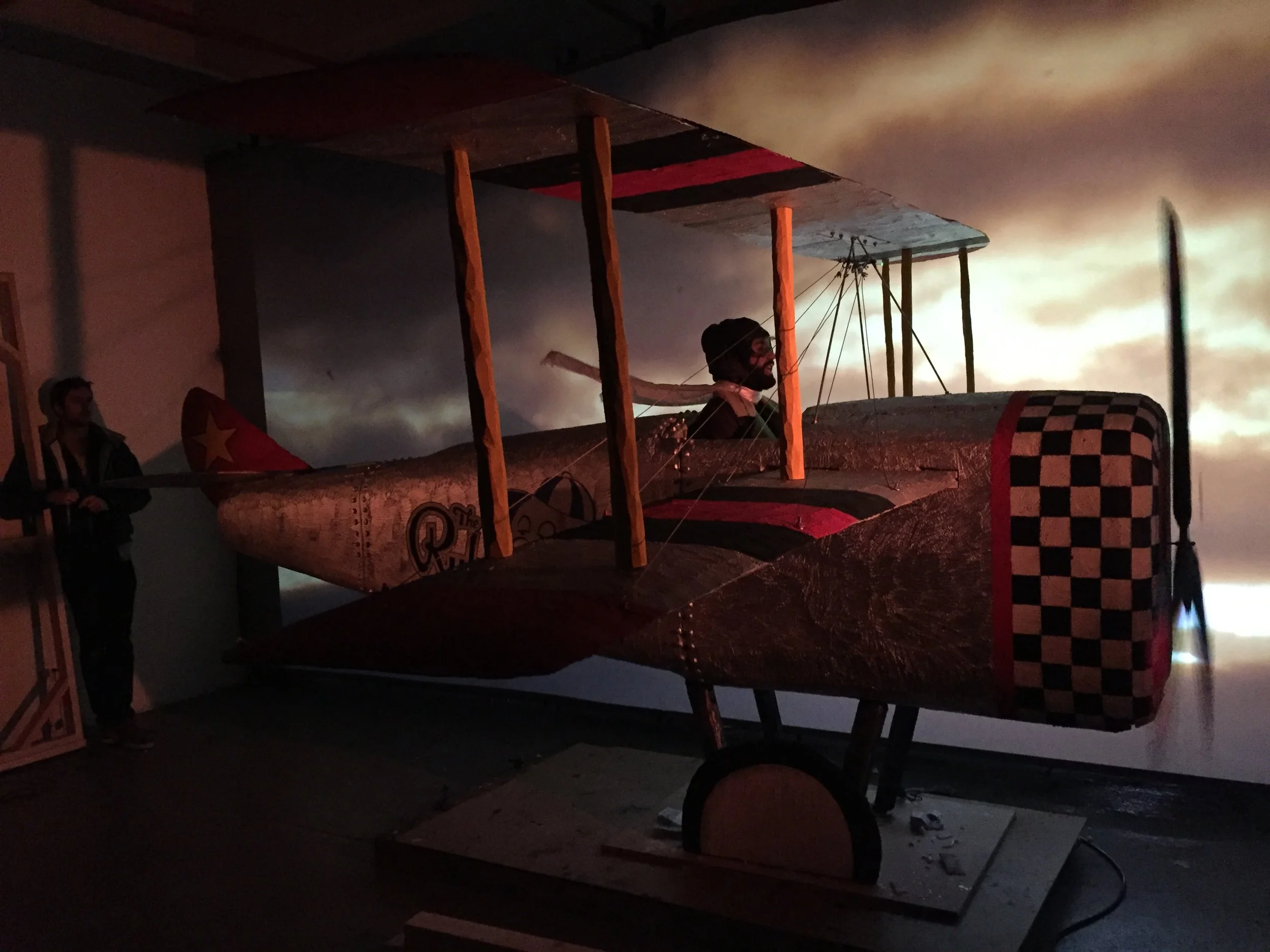 Actor Jonathan Campolo flies his bi-plane while Luke Alie manipulates the scarf