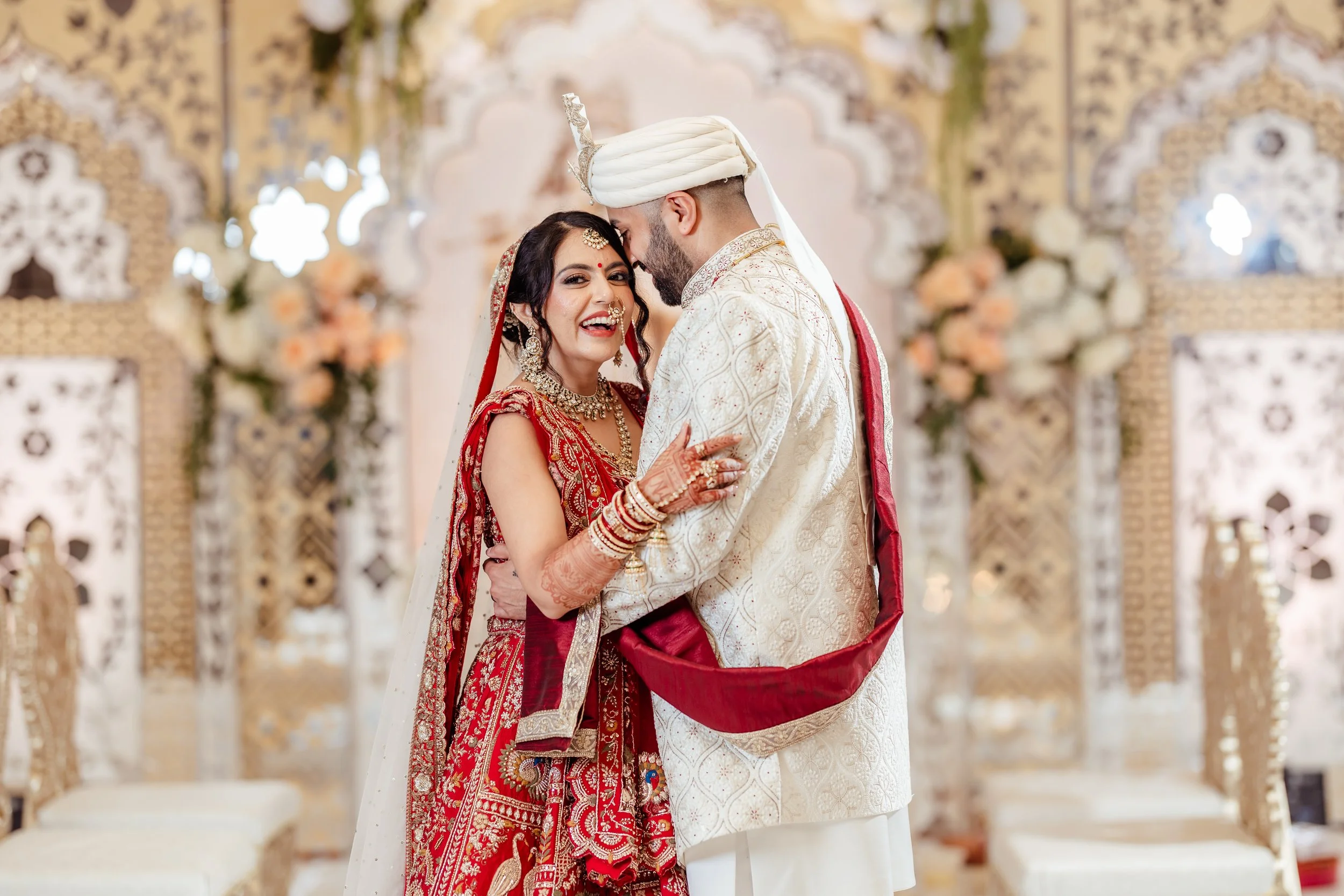 Meghan smiles as Nick kisses her forehead during their South Asian wedding at Hilton Atlanta Northeast.