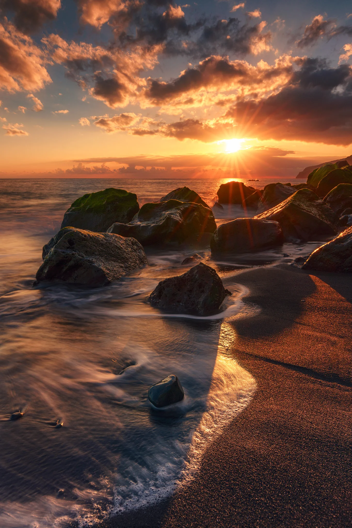 sunset at Madeira. A 6 Stop ND-Filter was used to achieve the streaks in the receding waves. And and a 0.9 graduated ND filter was used to capture more of the high dynamics by darkening the bright sky.