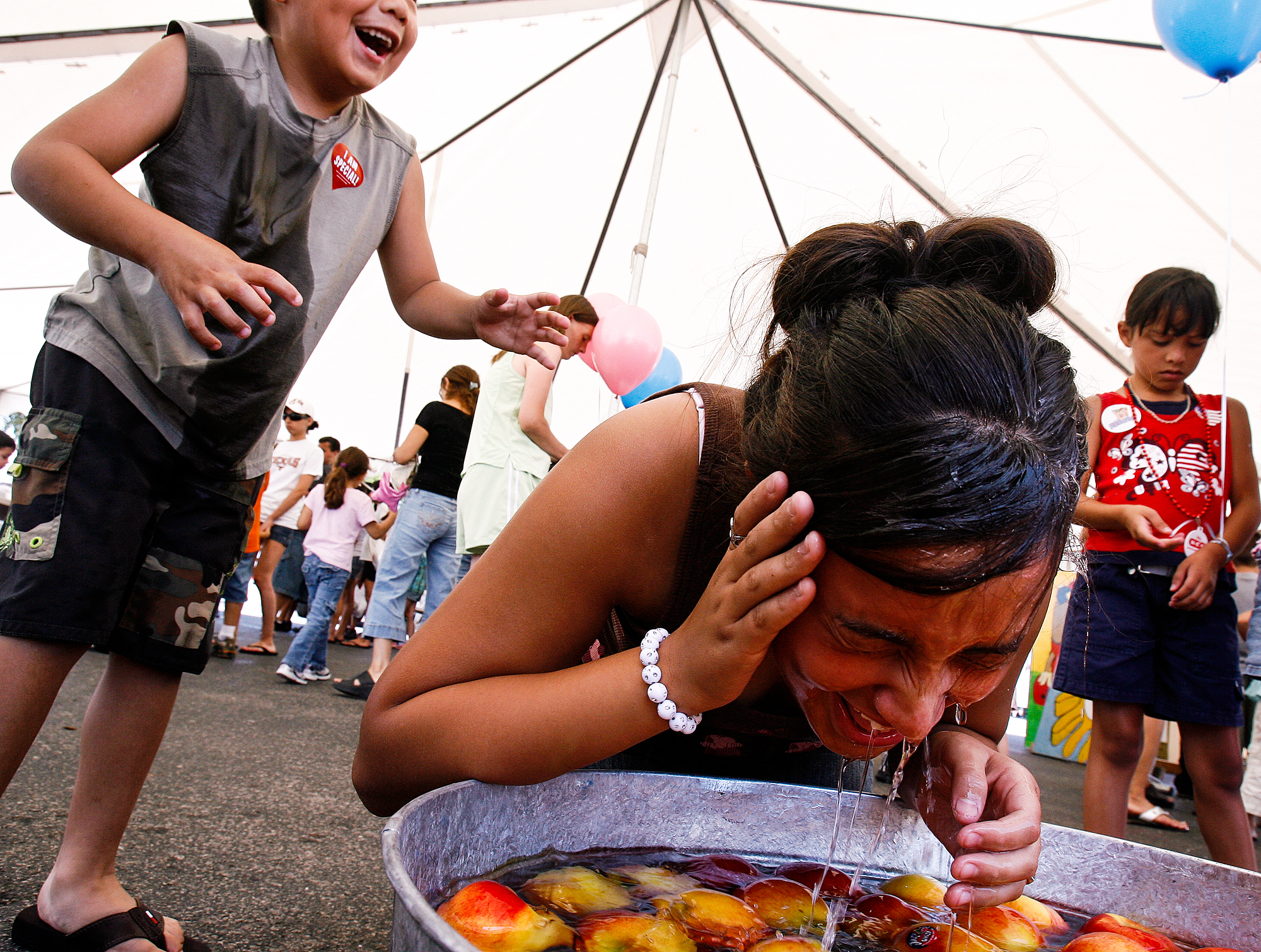  Ethan Garcia, 5, left, laughs after he executed revenge on his older sister Ariel Garcia, 11, by pushing her head into a tub of water while she bobbed for apples August, 26, 2007, in Odessa, Texas. 