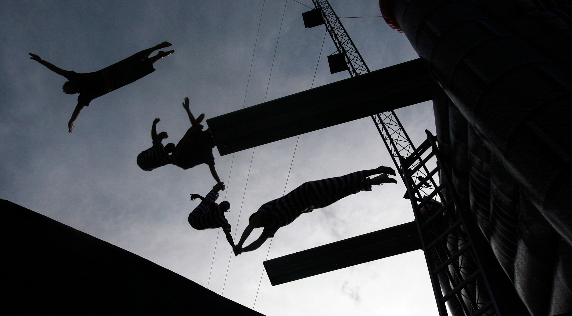  Performers in a high dive act fly through the air as they plunge toward their 9 1/2-foot-deep tank Sept. 8, 2007, at the fairgrounds in Odessa, Texas. 