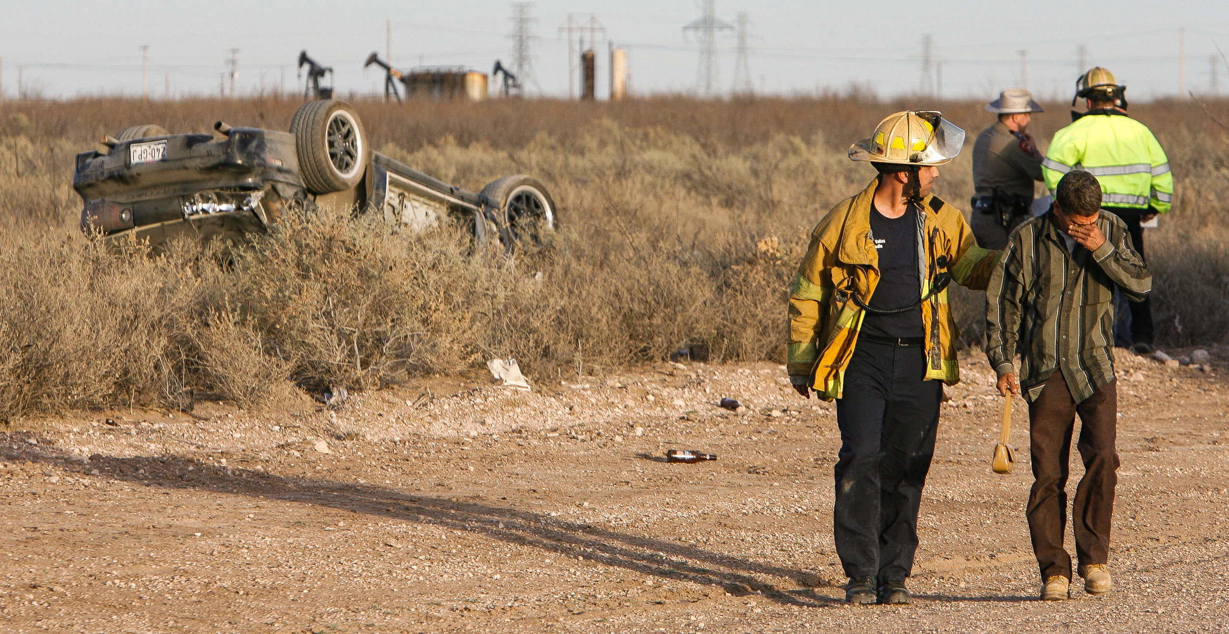  After identifying the body of Rebeca Salinas, 18, her father, right, walks away from the scene of a one-vehicle rollover with Odessa Fire Department captain Bobby Valles Wdnesday, March 1, 2007, on Damascus Road in West Odessa, Texas. A passenger, R