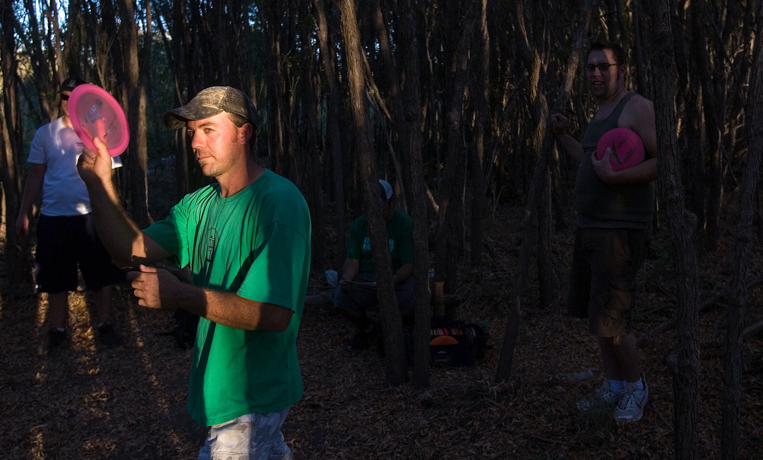  Bobby Baird, foreground, lines up a throw as Nick Cookman, background from left, Anthouny Aguirre and Clint Reefschneider watch during a disc golf mini-tournament Wednesday at Comanche Trail Park. Baird said their group of players is usually out at 