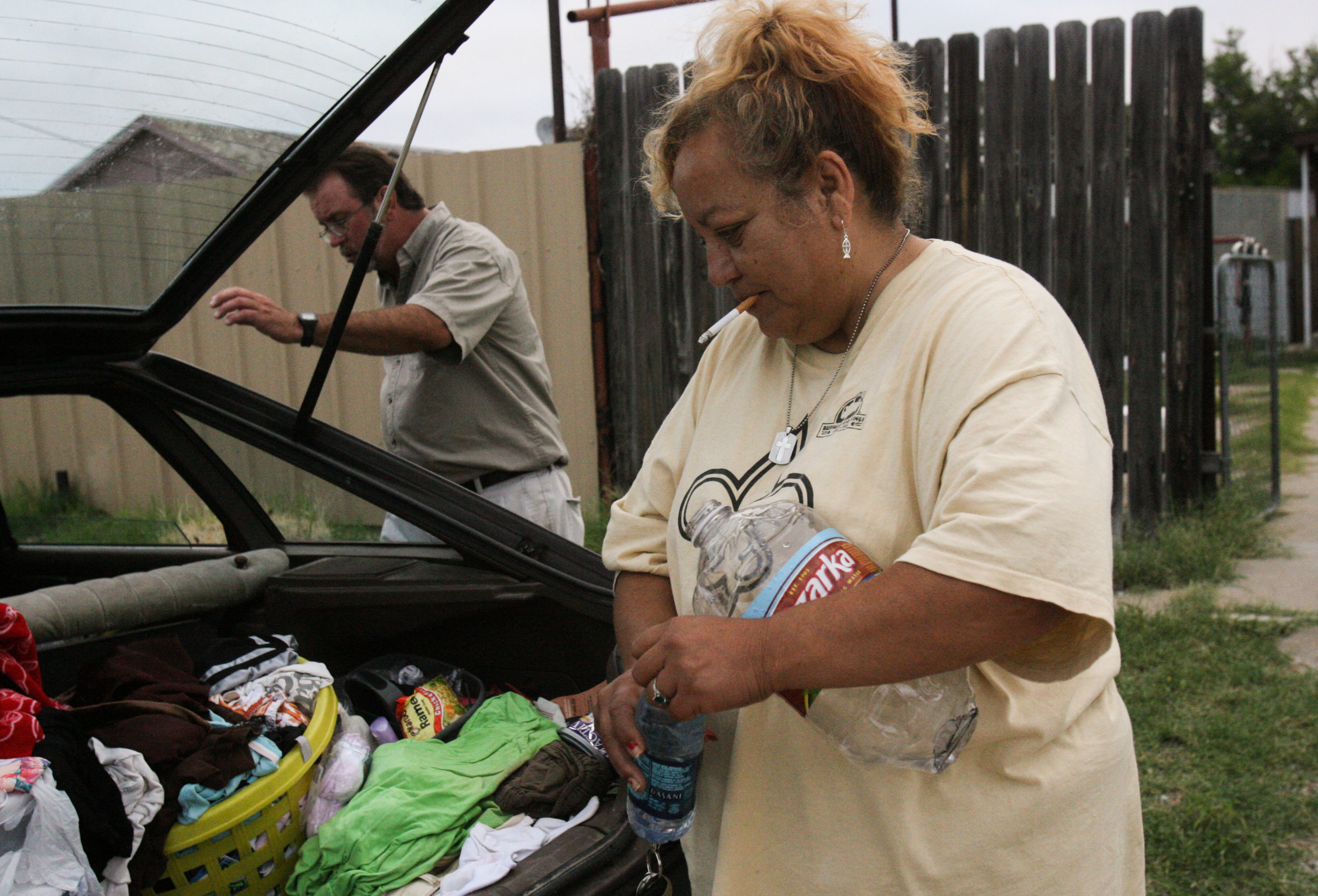  Juanita Torres, right, fills up a water bottle as she prepares to do laundry with fellow shelter resident Steve Seward at his mother's home Aug. 23, 2008, in Crane, Texas. 