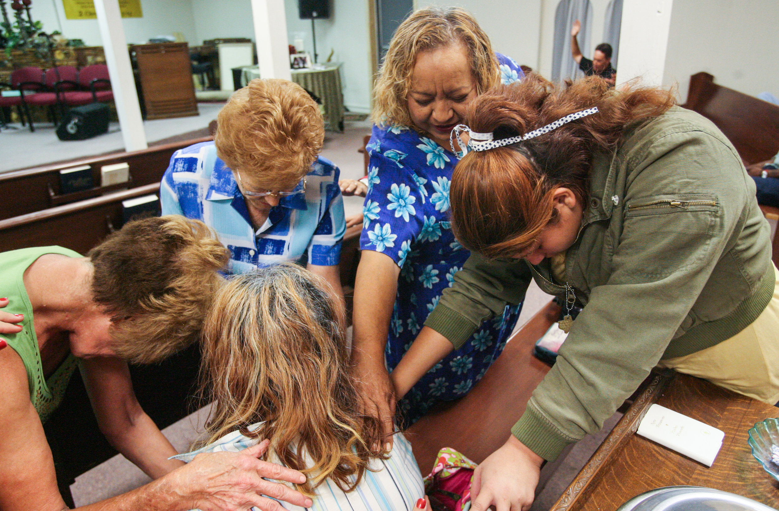  One day after moving into a new apartment, Angelica Brito, 12, from right, and her mother, Juanita Torres, pray with others for a fellow member of the congregation at Faith Temple Fellowship church in Odessa, Texas. The two attended the church, wher