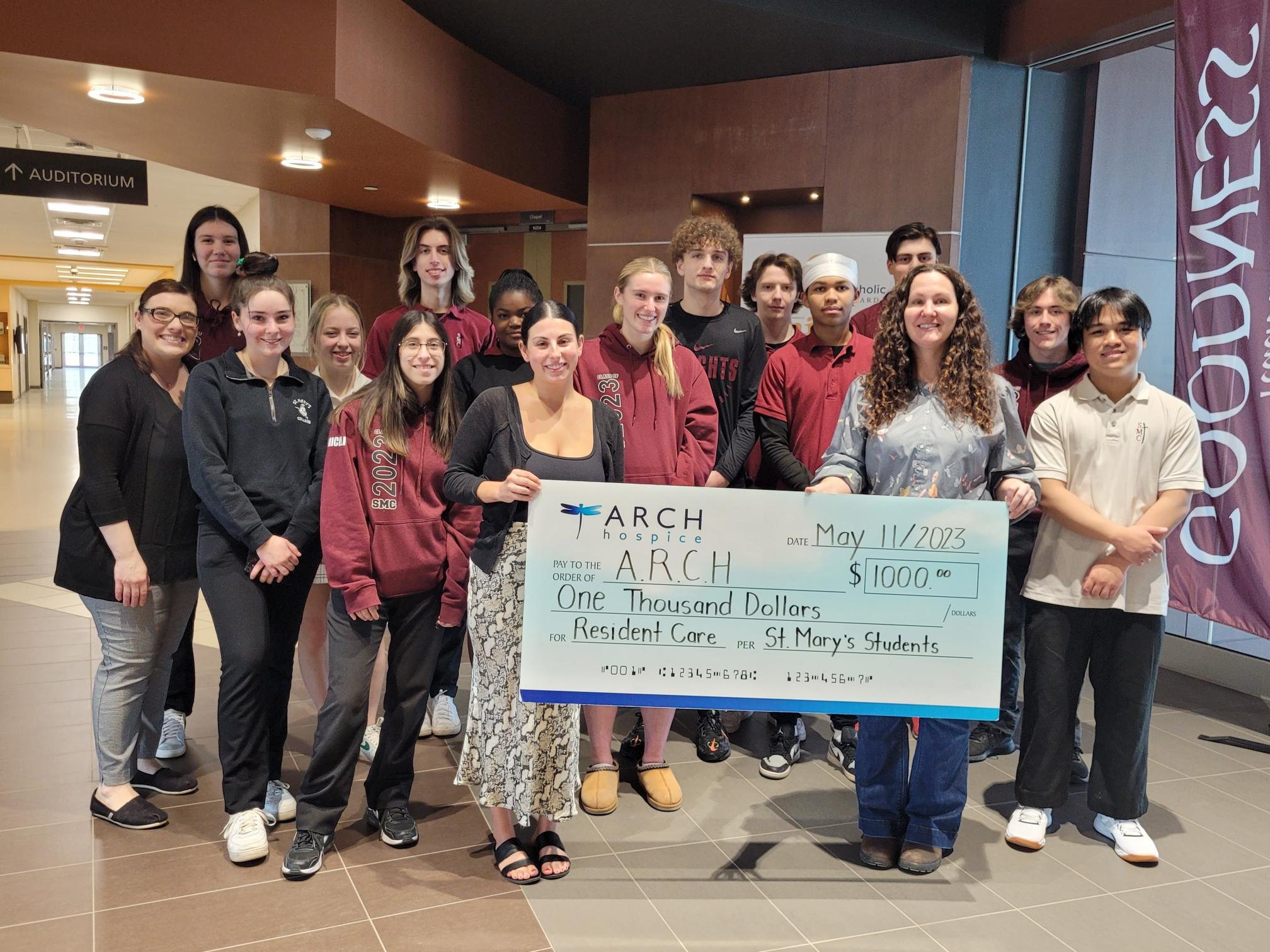Grade 12 Religion class students present cheque to representatives from ARCH.jpg