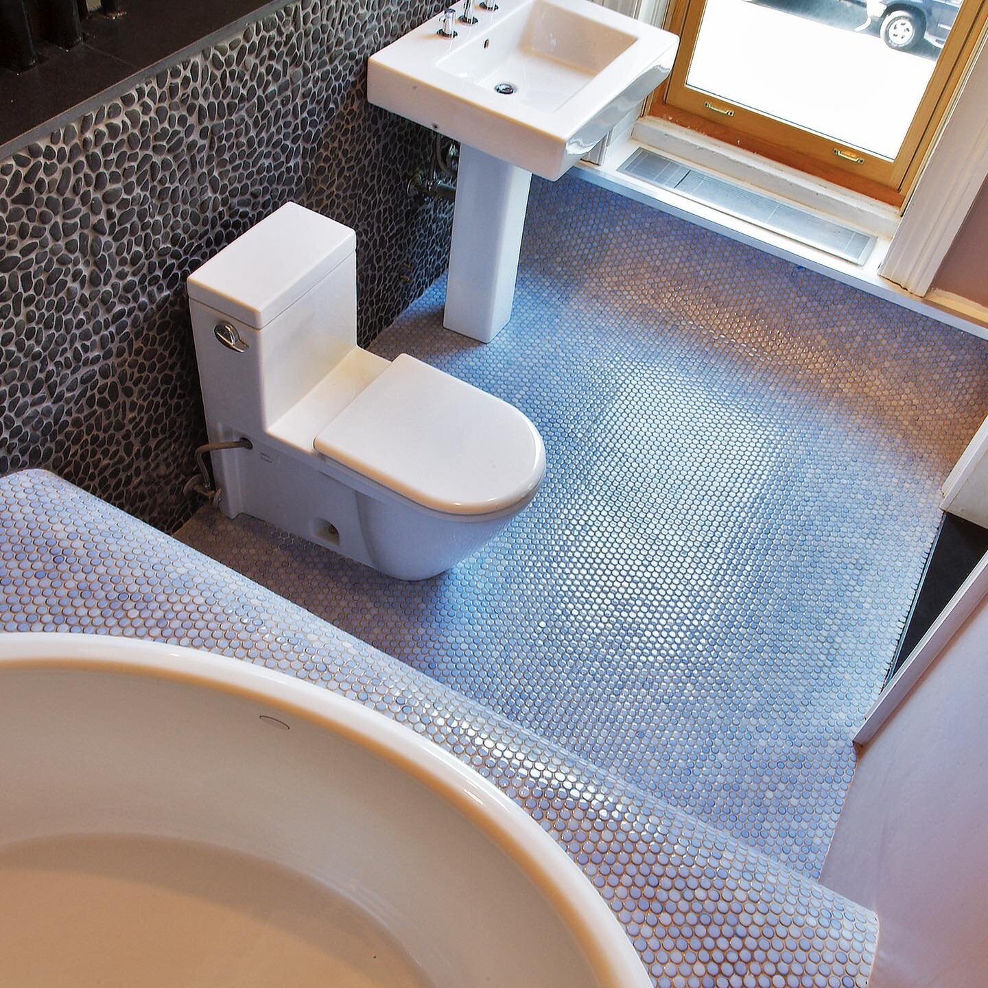 In this Fort Greene townhouse we created an undulating surface out of penny tiles that cascades down the wall, over the tub deck, down to the floor and up to the window sill. 
-
-
-
-
#brooklyntownhouse #architecture #townhouserenovation #interiordes